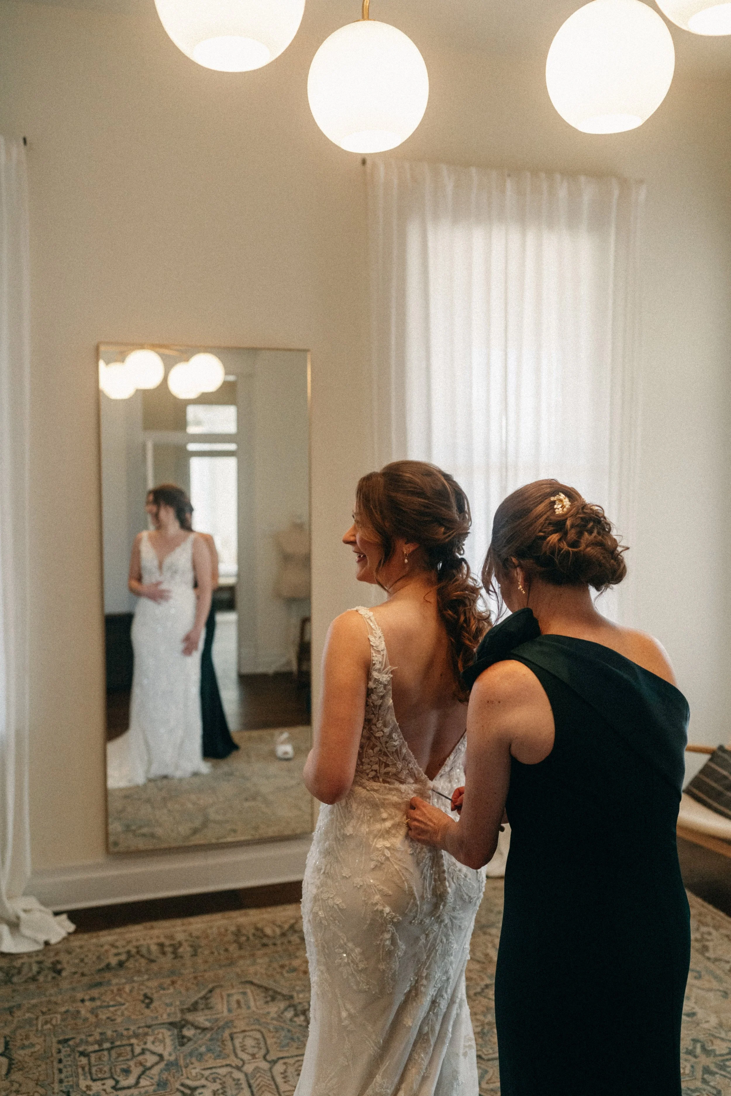Mother of the Bride getting helping bride get into her bridal gown in mansion suite at The Grand Lady in manor tx just outside of austin