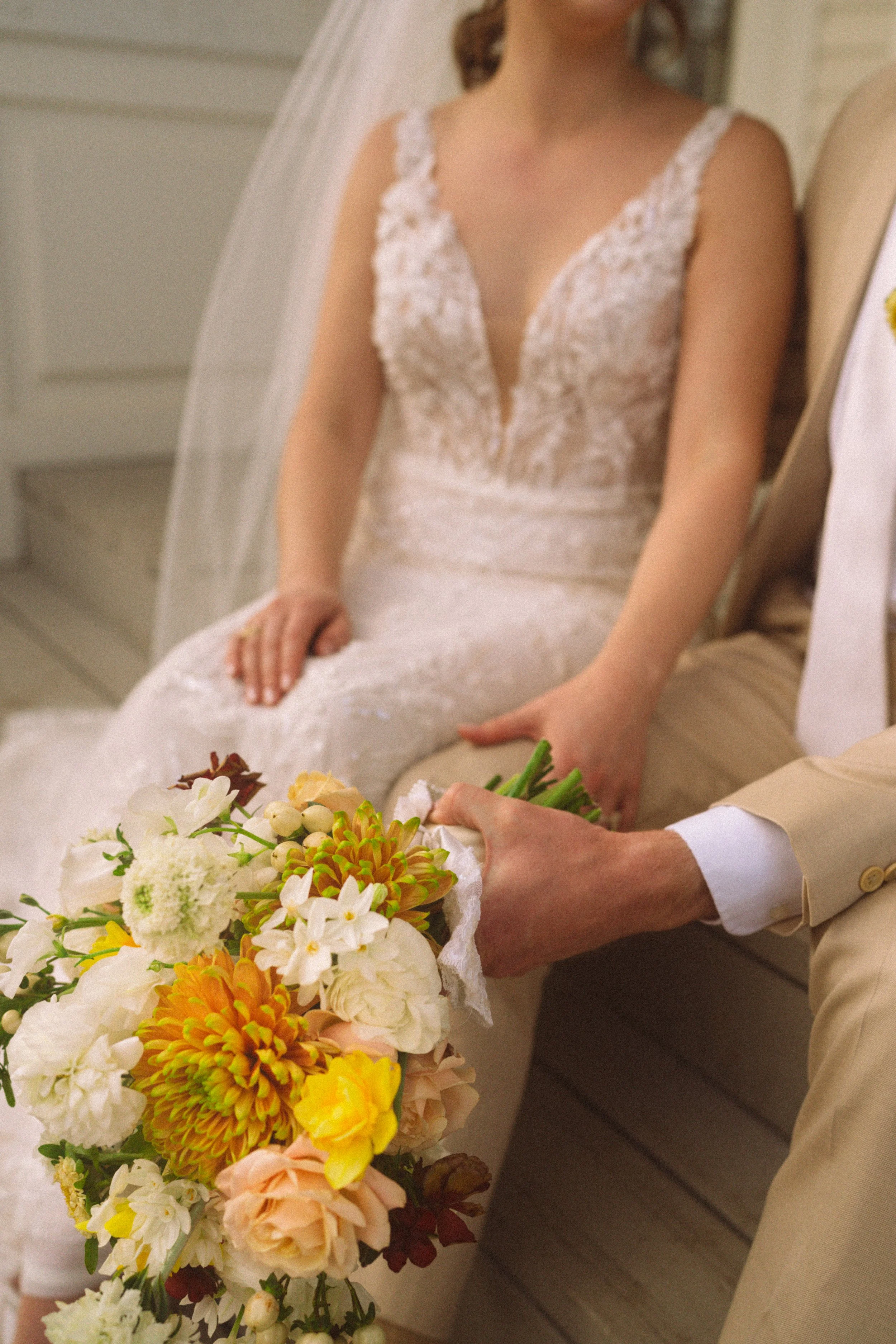 Bride and groom sitting in front of The Grand Lady historic mansion