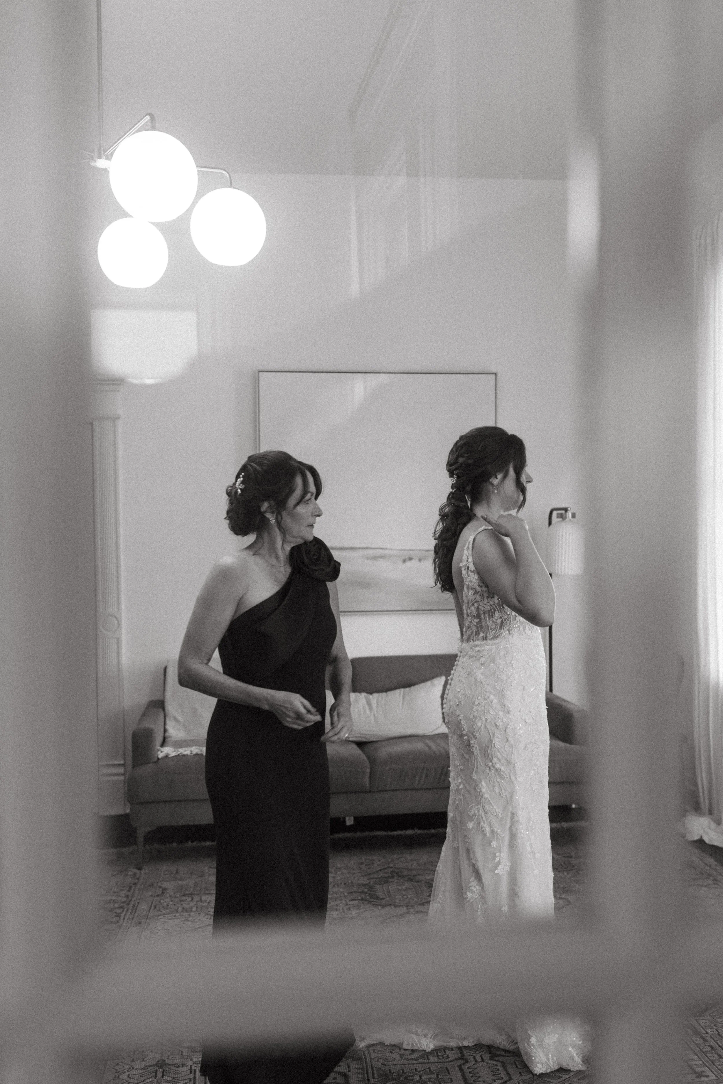 candid of Mother of the Bride getting helping bride get into her bridal gown in mansion suite at The Grand Lady in manor tx just outside of austin