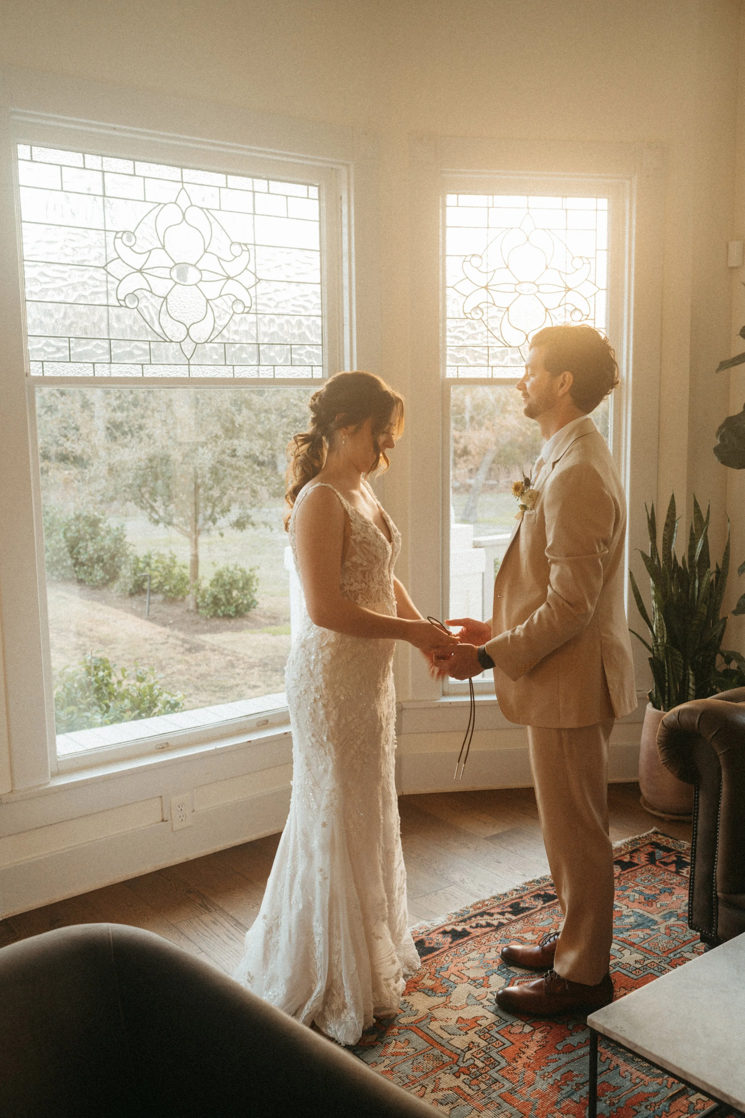 Couple exchanging wedding gifts by the grand windows at The Grand Lady in Austin