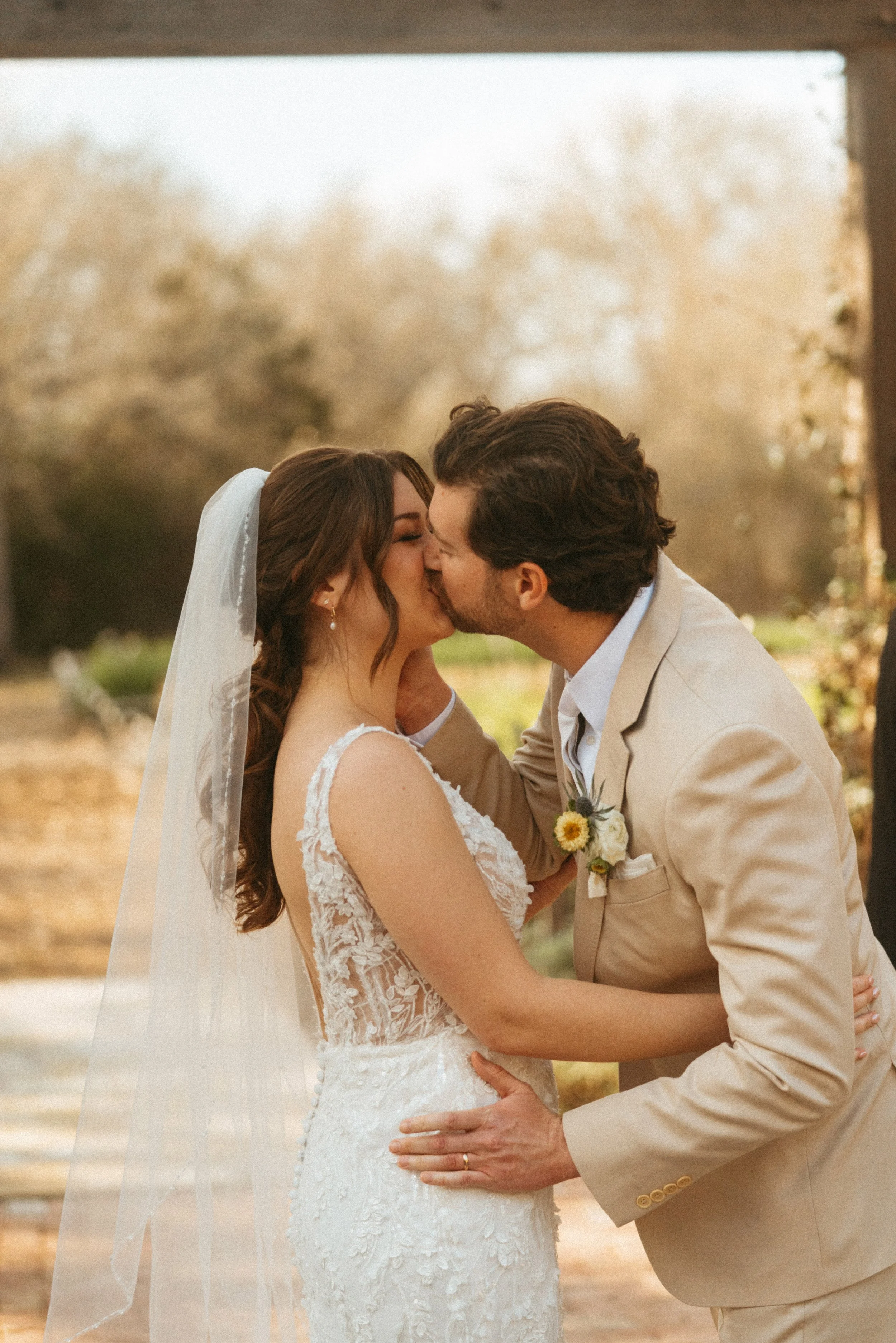 Bride and groom share first kiss under pergola at The Grand Lady wedding ceremony