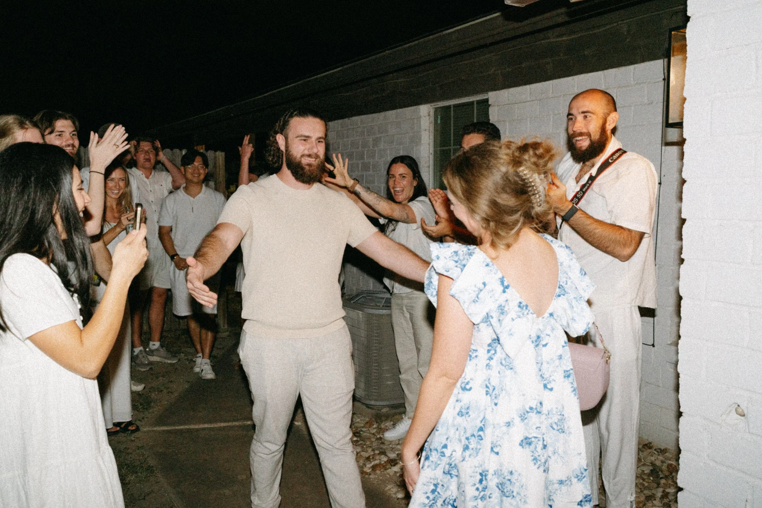 Documentary style wedding photography of couple celebrating engagement with loved ones