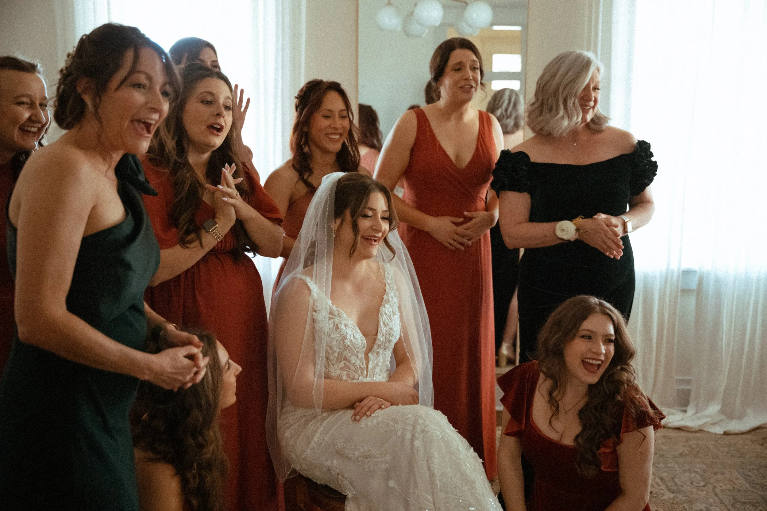 traditional wedding candid of the bride being prayed over by her bridesmaids in the light airy bridal suite at The Grand Lady in manor tx just outside of austin