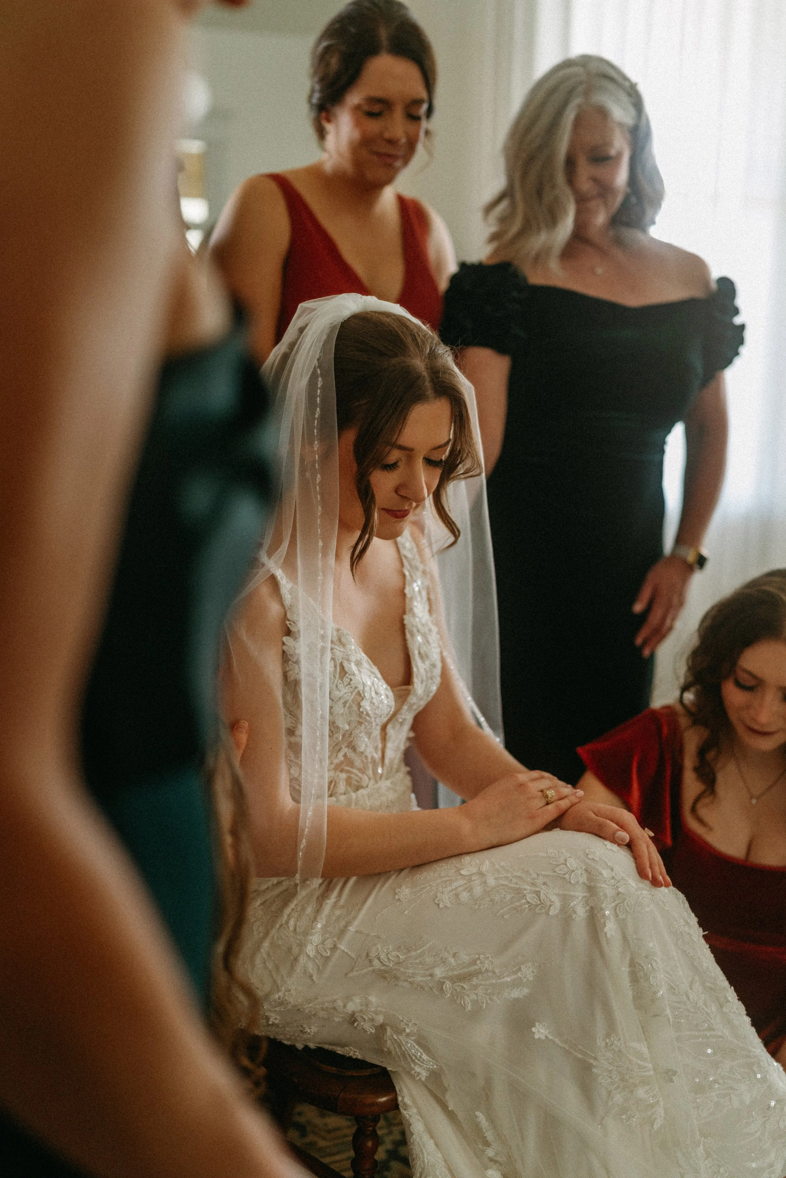 documentary style wedding photography candid of the bride being prayed over by her bridesmaids in the light airy bridal suite at The Grand Lady in manor tx just outside of austin