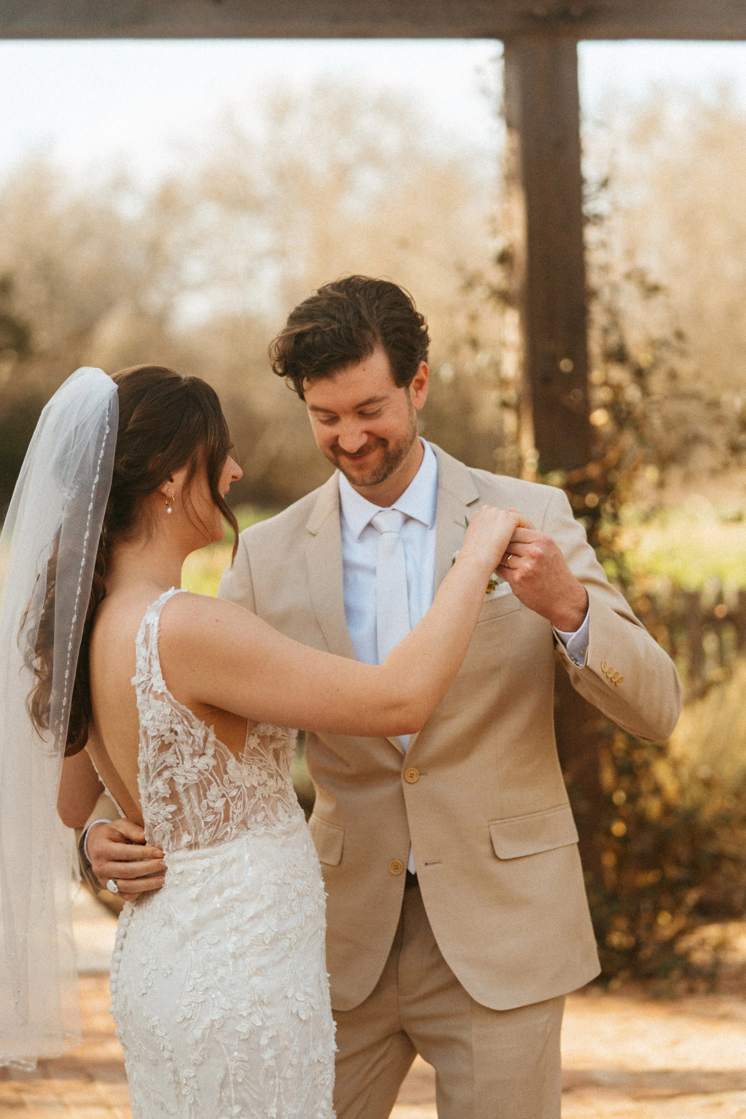 Bride and groom share first kiss under pergola at The Grand Lady wedding ceremony