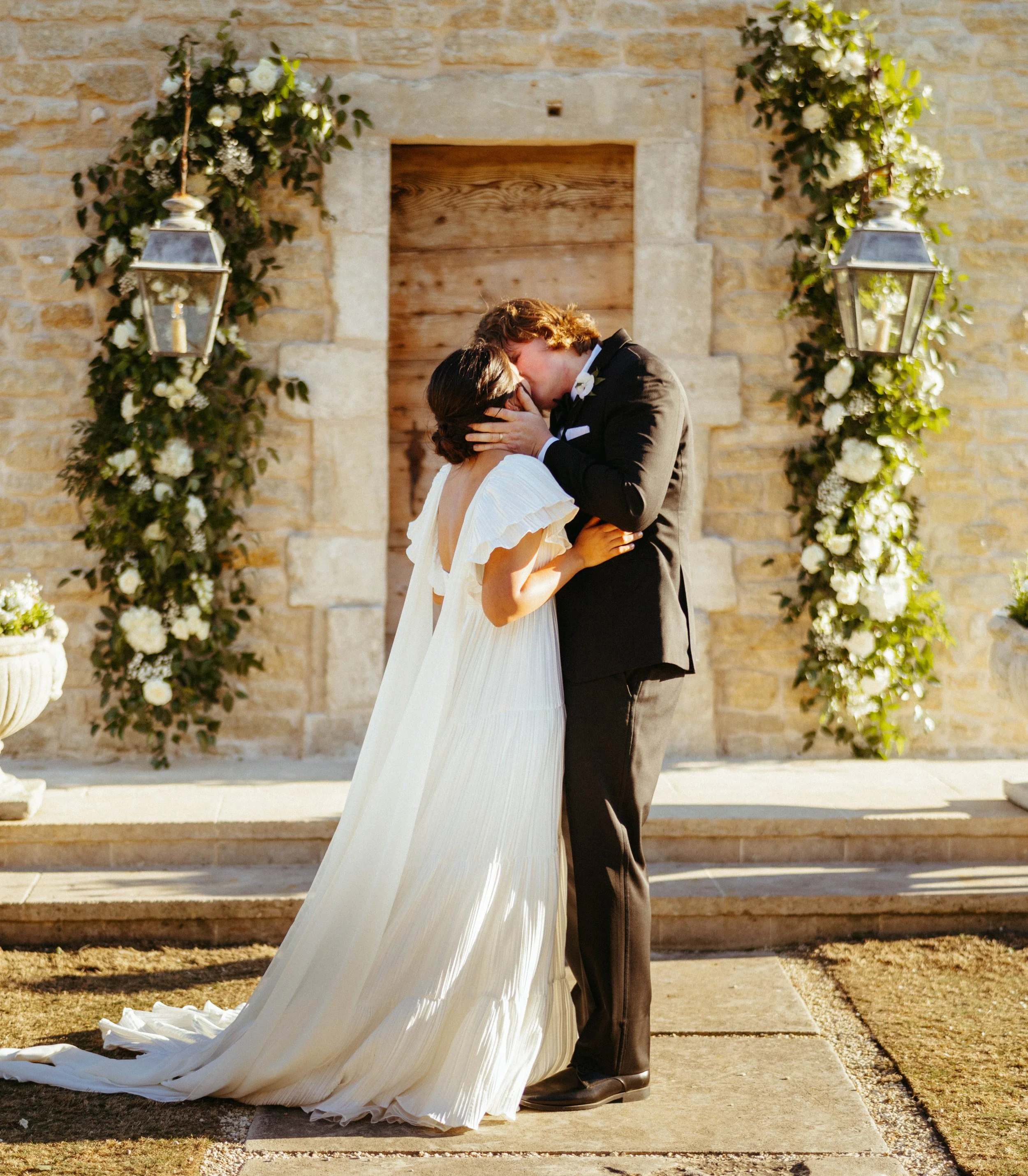Bride and groom sharing their first kiss as husband and wife at Houston Oaks Country Club.