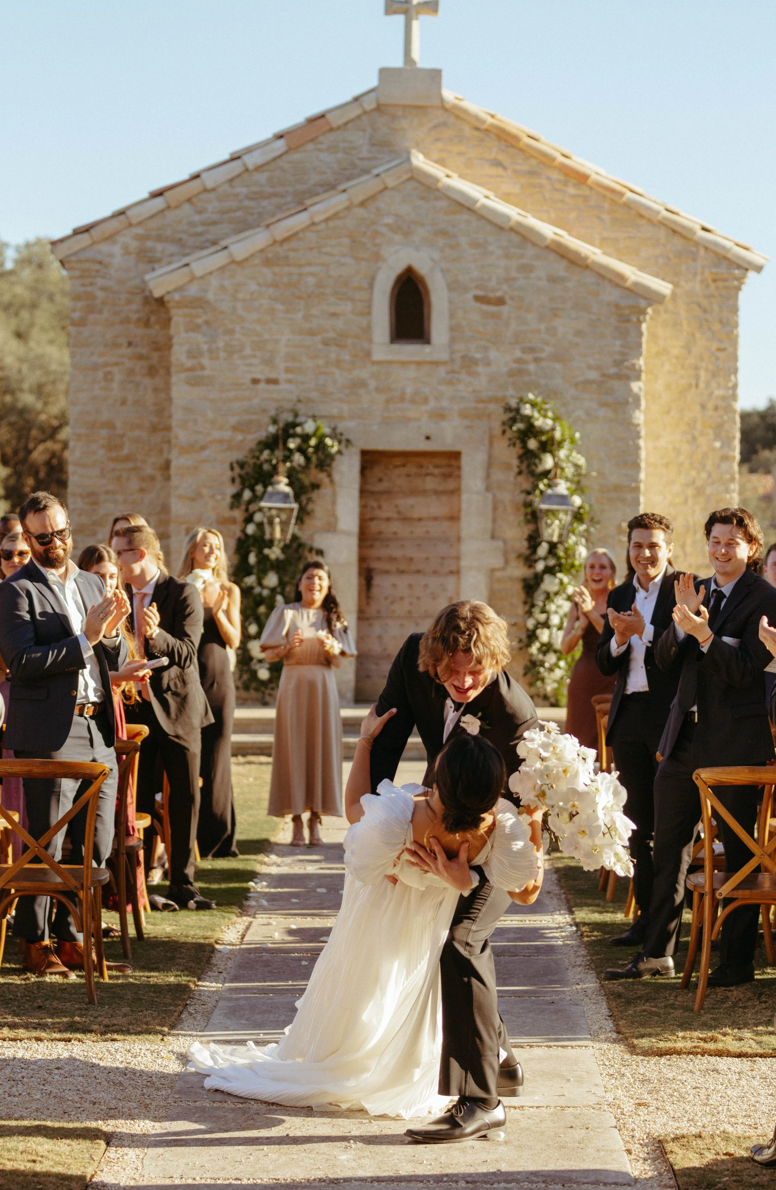 Groom dipping his bride at recessional | Outdoor wedding ceremony at Houston Oaks Country Club French chapel.