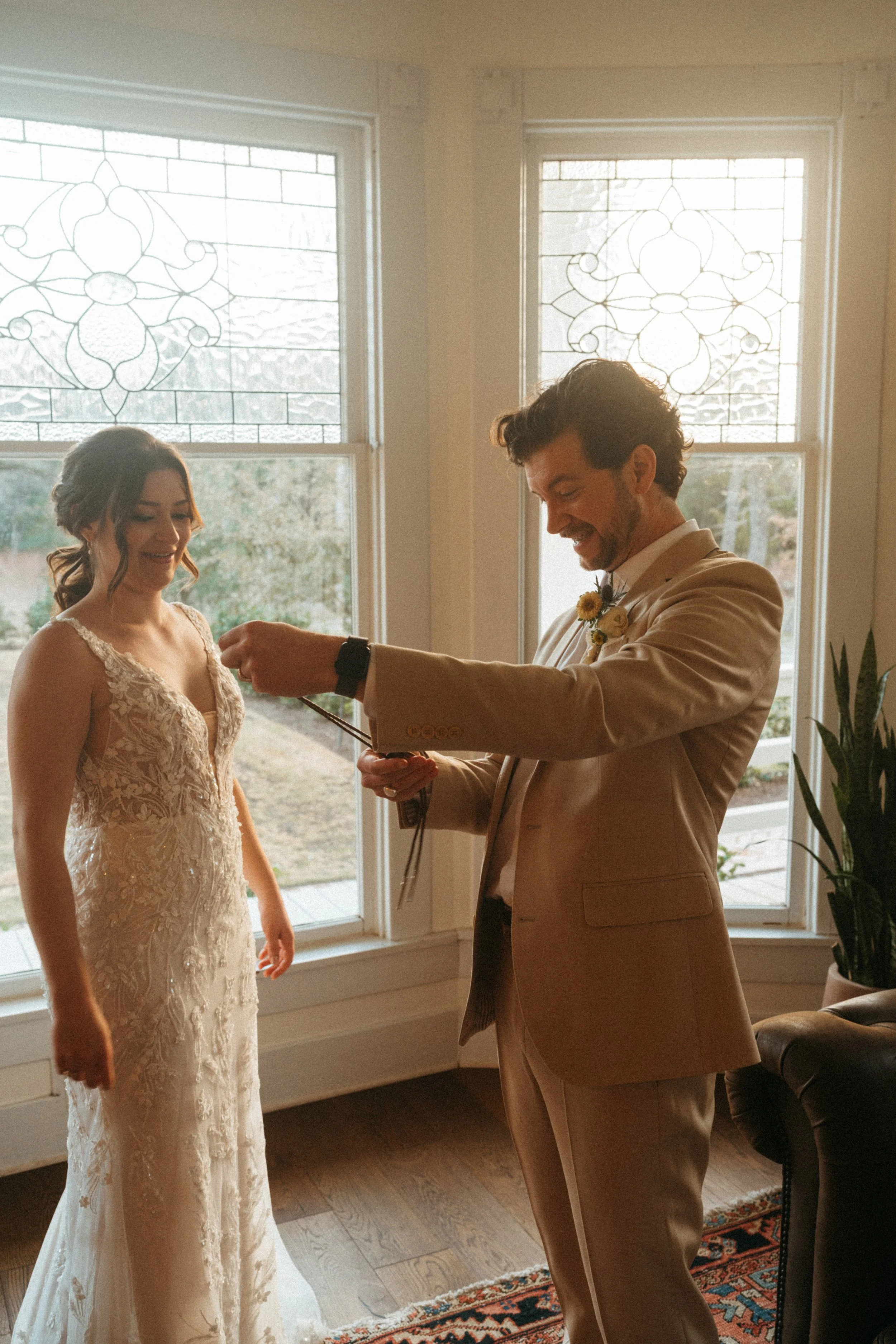 Couple exchanging wedding gifts by the grand windows at The Grand Lady in Austin