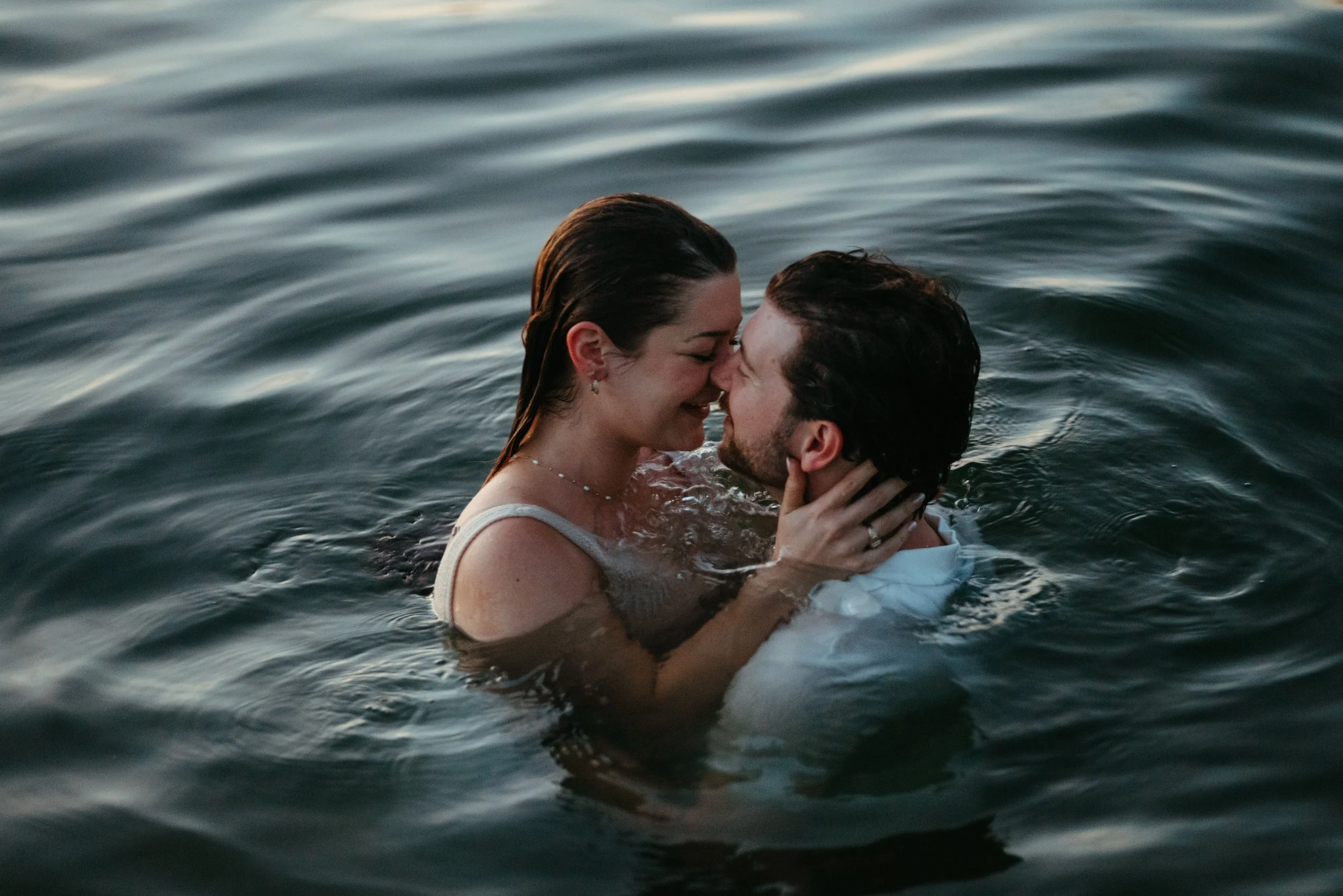 Couple kissing in the lake at Emma Long Park during Austin proposal blue hour photography