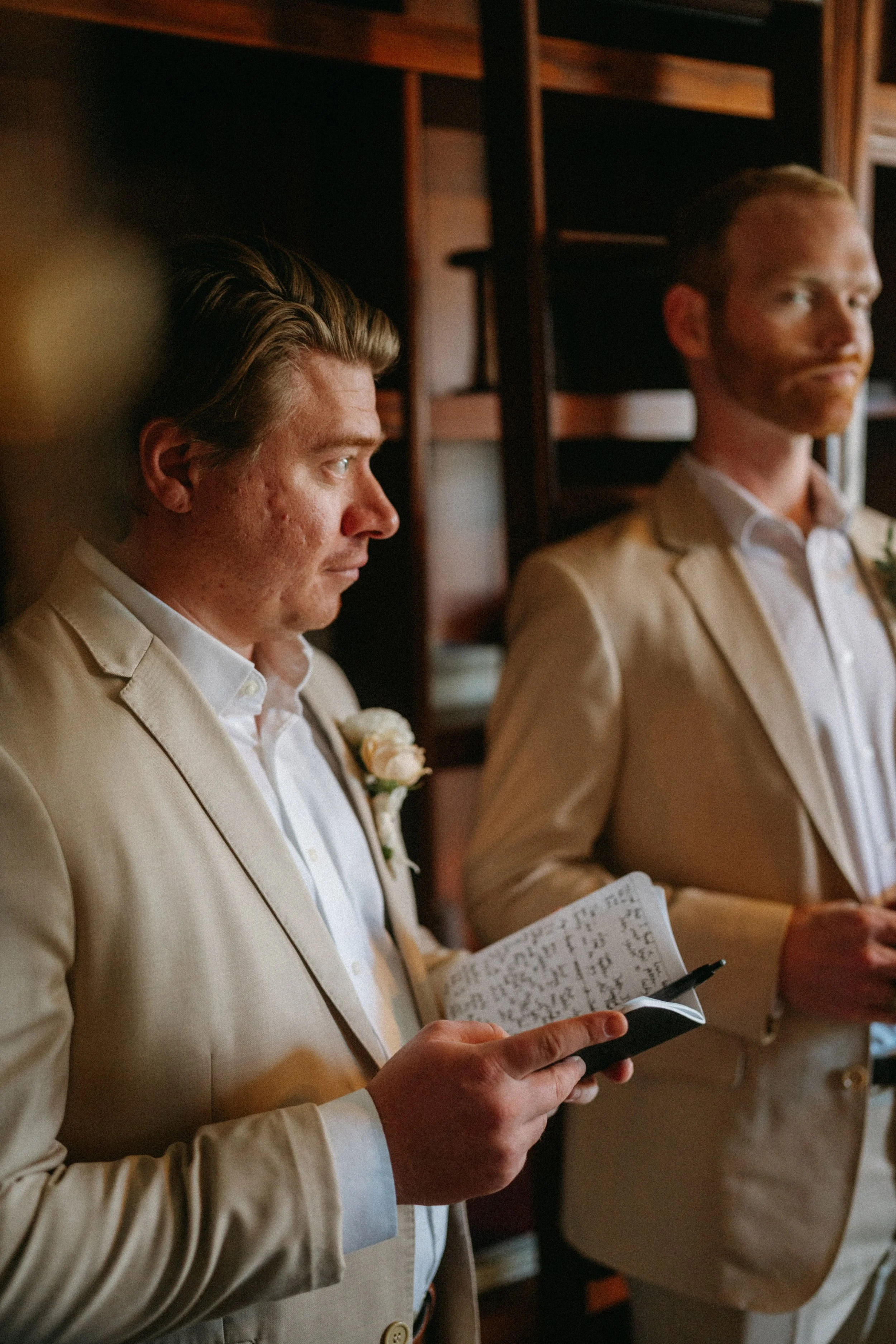 documentary style wedding photography candid of the groom and groomsmen in the old money library at The Grand Lady in manor tx just outside of austin