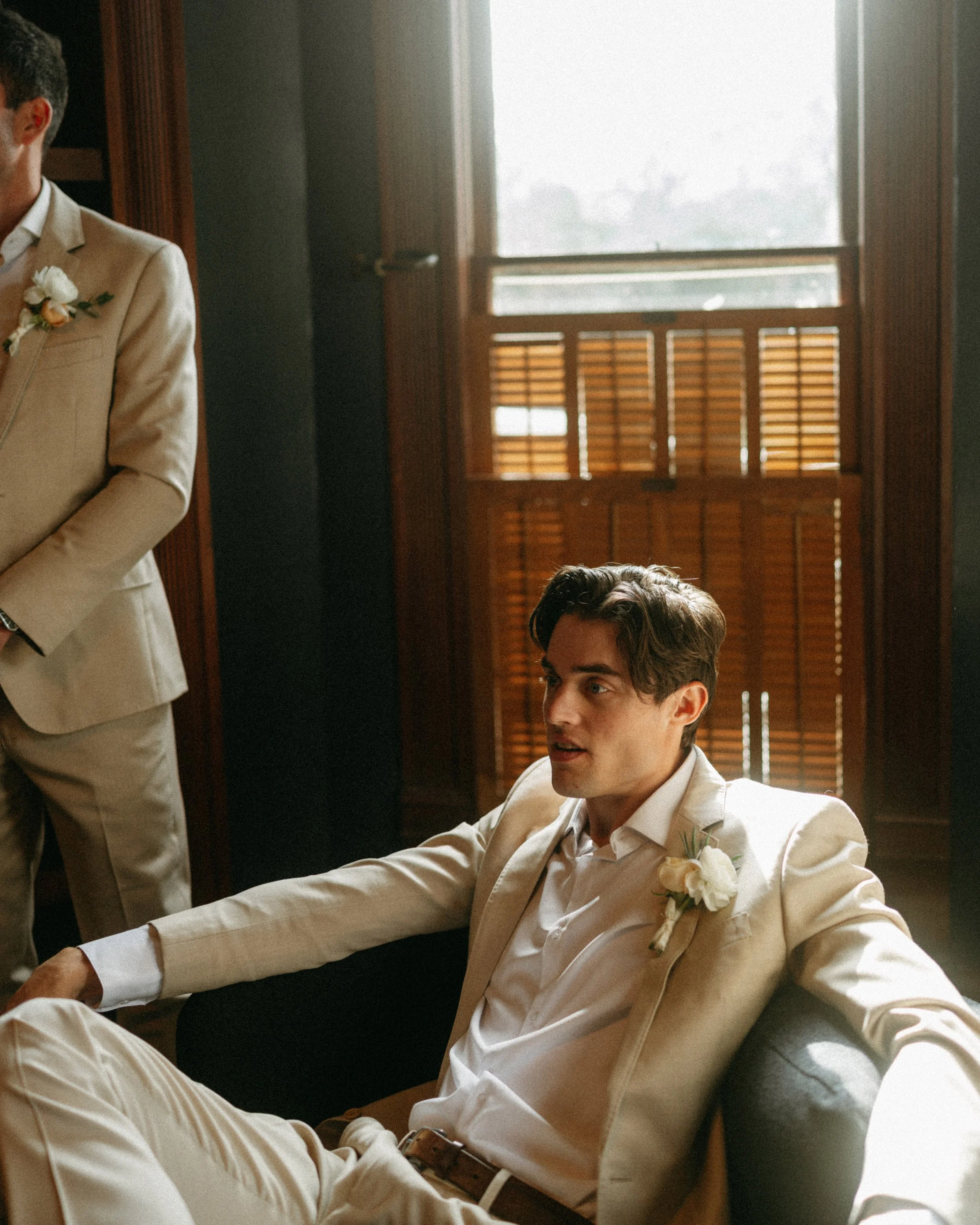 documentary style wedding photography candid of the groom and groomsmen in the old money library at The Grand Lady in manor tx just outside of austin