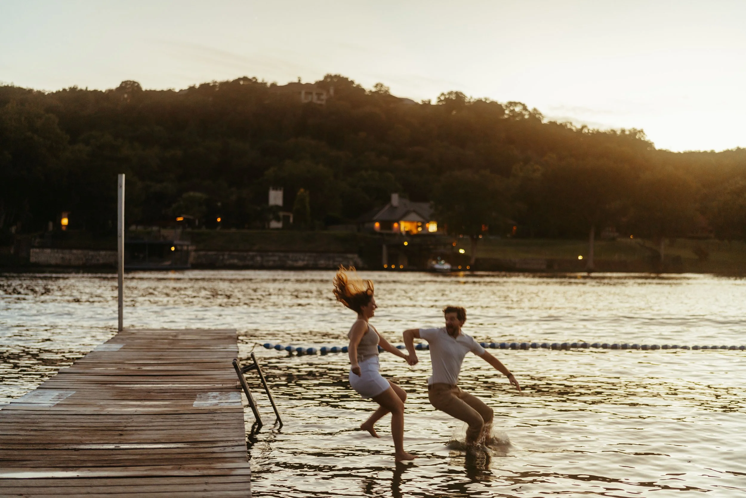 Austin wedding photographer capturing spontaneous lake jump after proposal