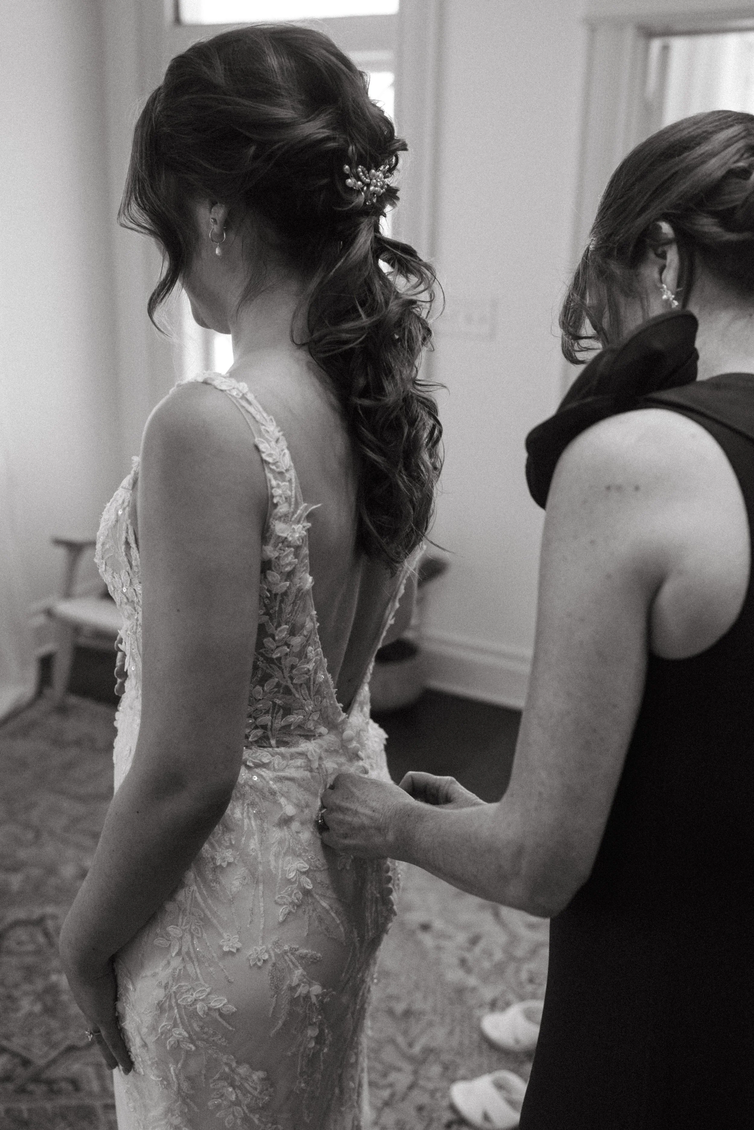 Mother of the Bride getting helping bride get into her bridal gown in mansion suite at The Grand Lady in manor tx just outside of austin
