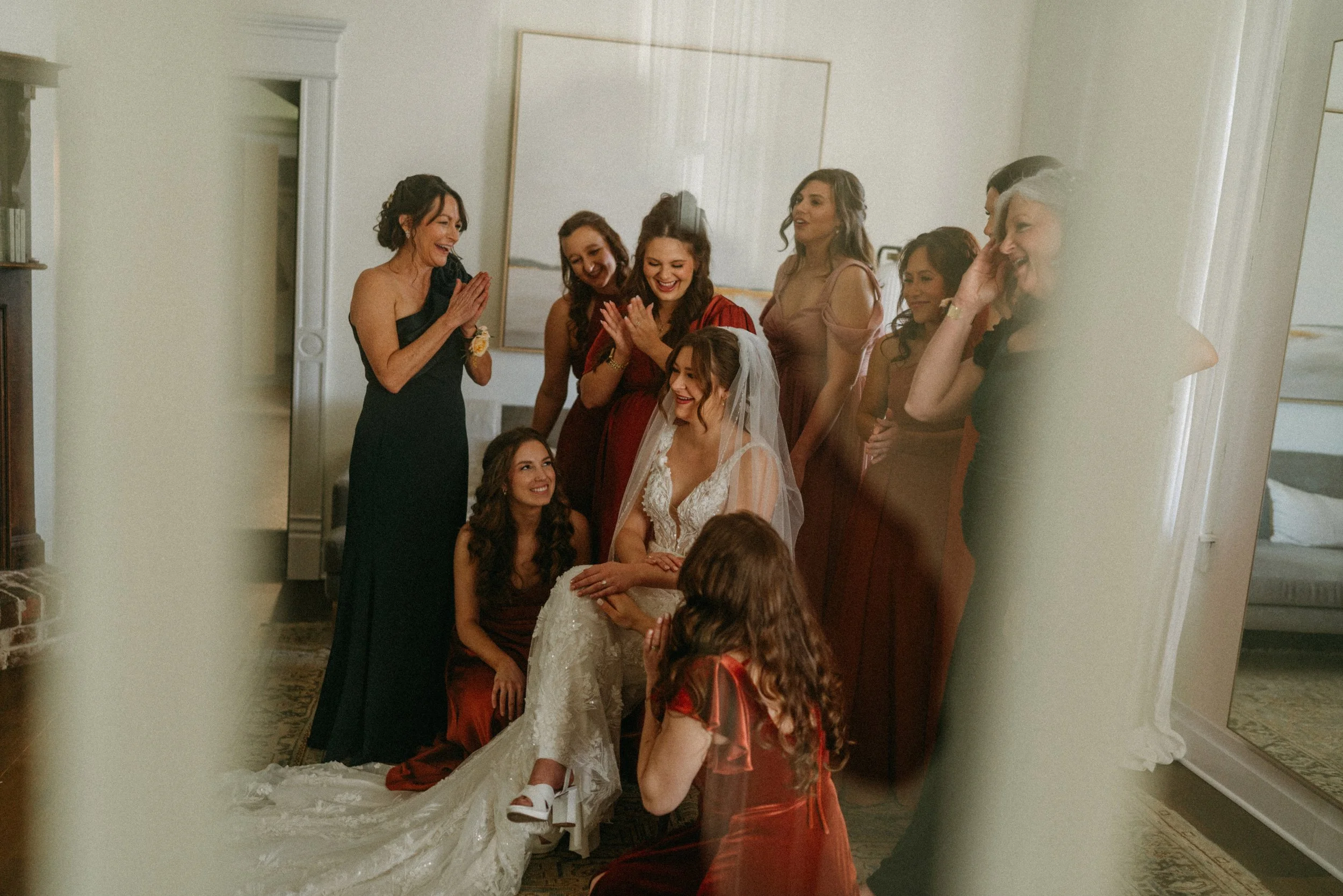 documentary style wedding photography candid of the bride being prayed over by her bridesmaids in the light airy bridal suite at The Grand Lady in manor tx just outside of austin