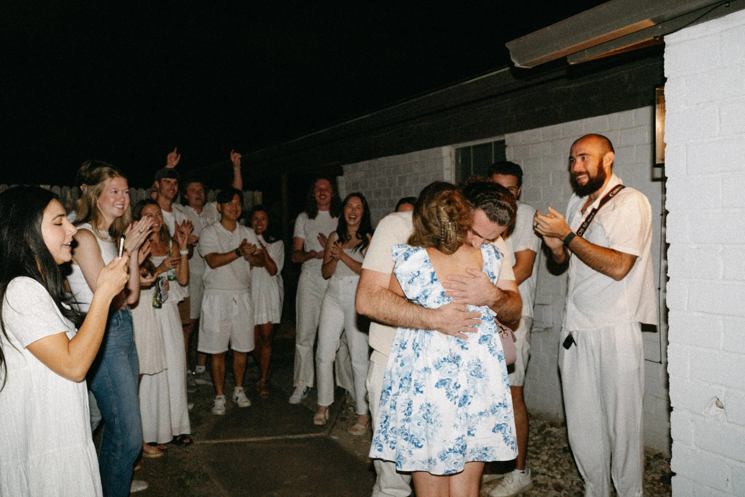 Documentary style wedding photography of couple celebrating engagement with loved ones