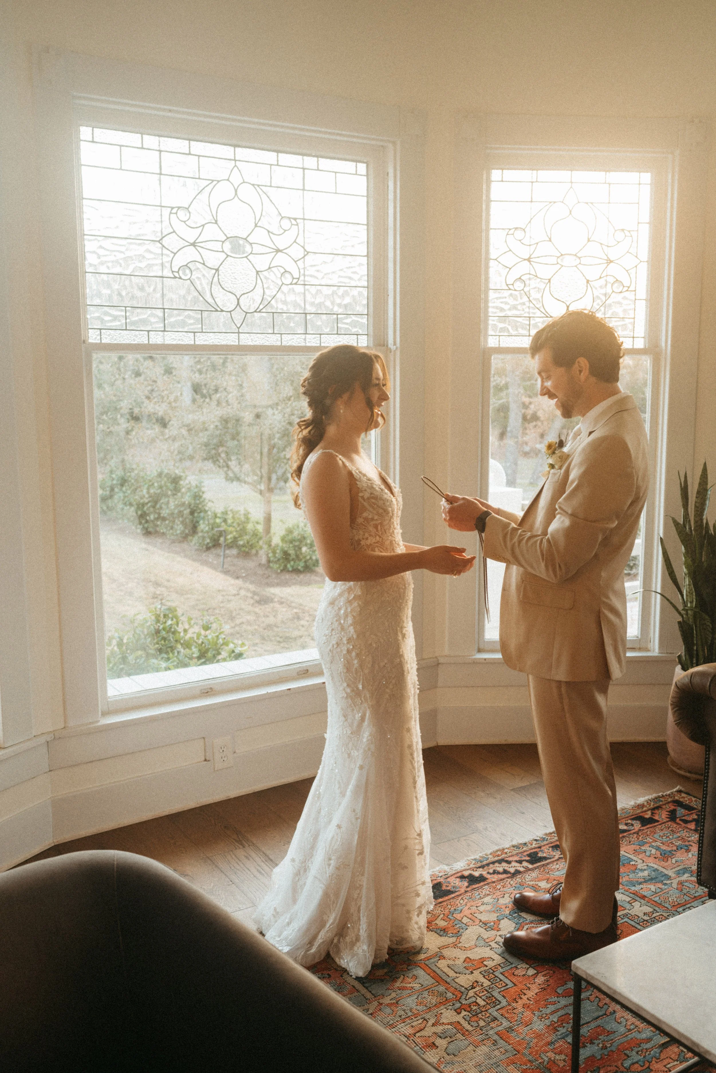 Couple exchanging wedding gifts by the grand windows at The Grand Lady in Austin