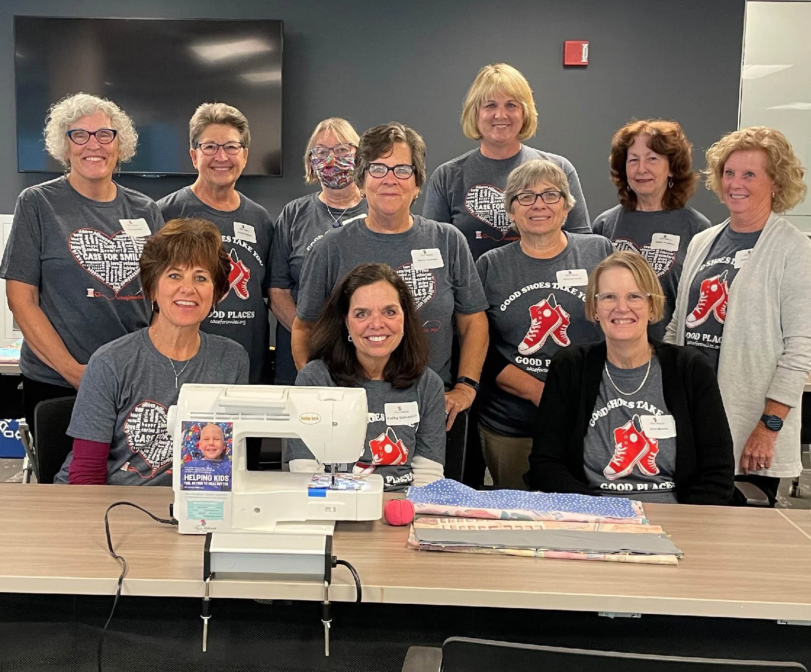 Volunteers behind a sewing machine making pillowcases