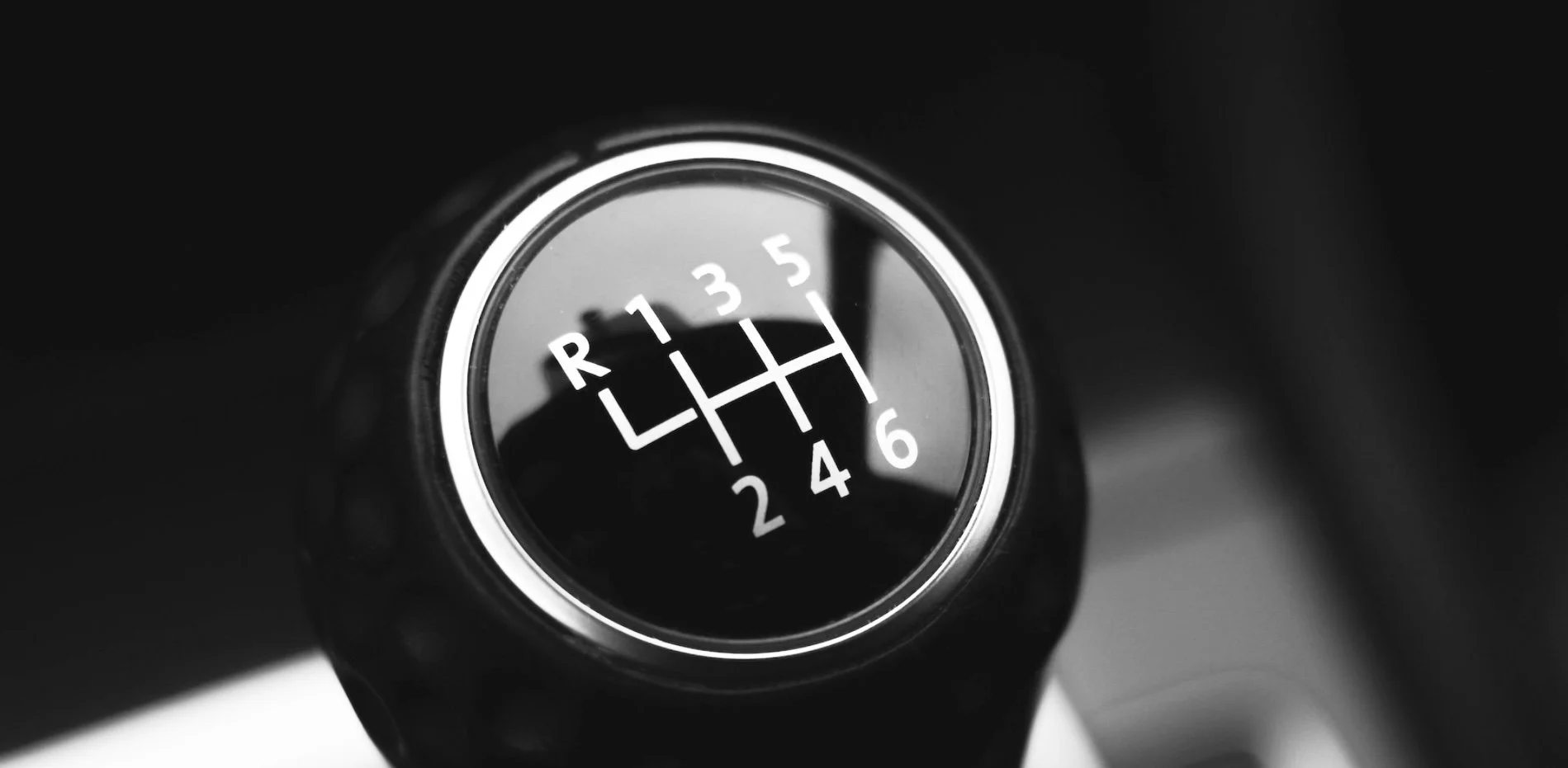 Close-up of a black manual transmission gear shift knob—perfect for mastering shifts in manual car lessons.