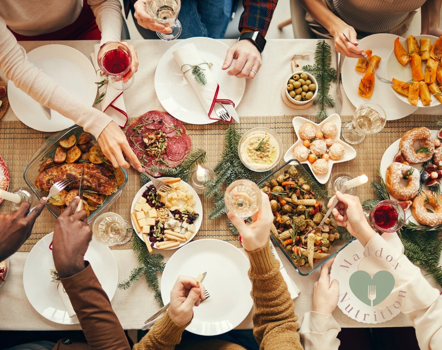 Friends toast with wine glasses over a bountiful Christmas feast, showcasing a mindful holiday non-diet approach to seasonal celebrations.