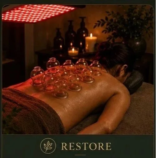 Person receiving a cupping therapy massage in a spa setting with candles and decorative bottles in the background.