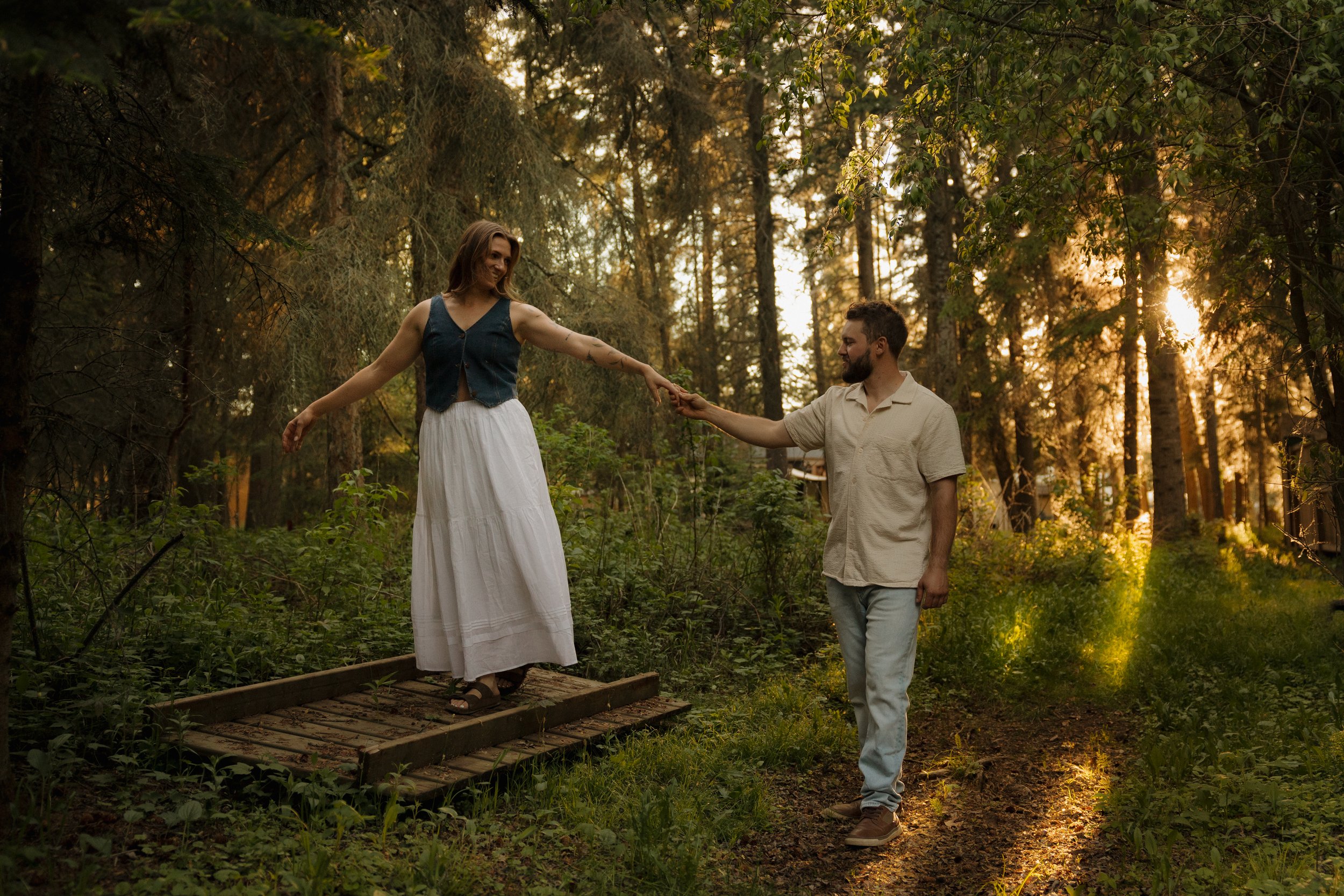 man and woman walking through forest
