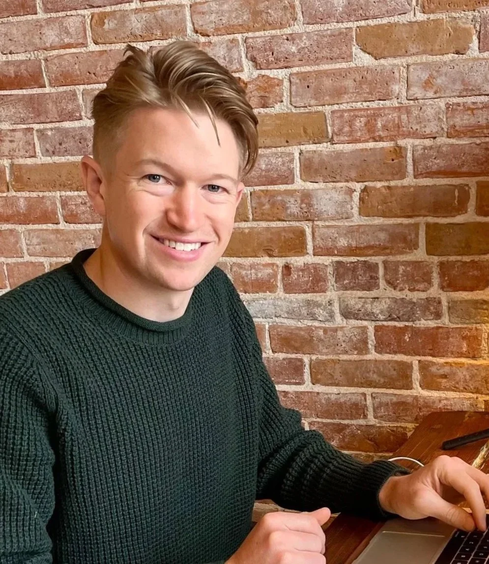 Andrew Herwig, financial coach, smiling at a café table.