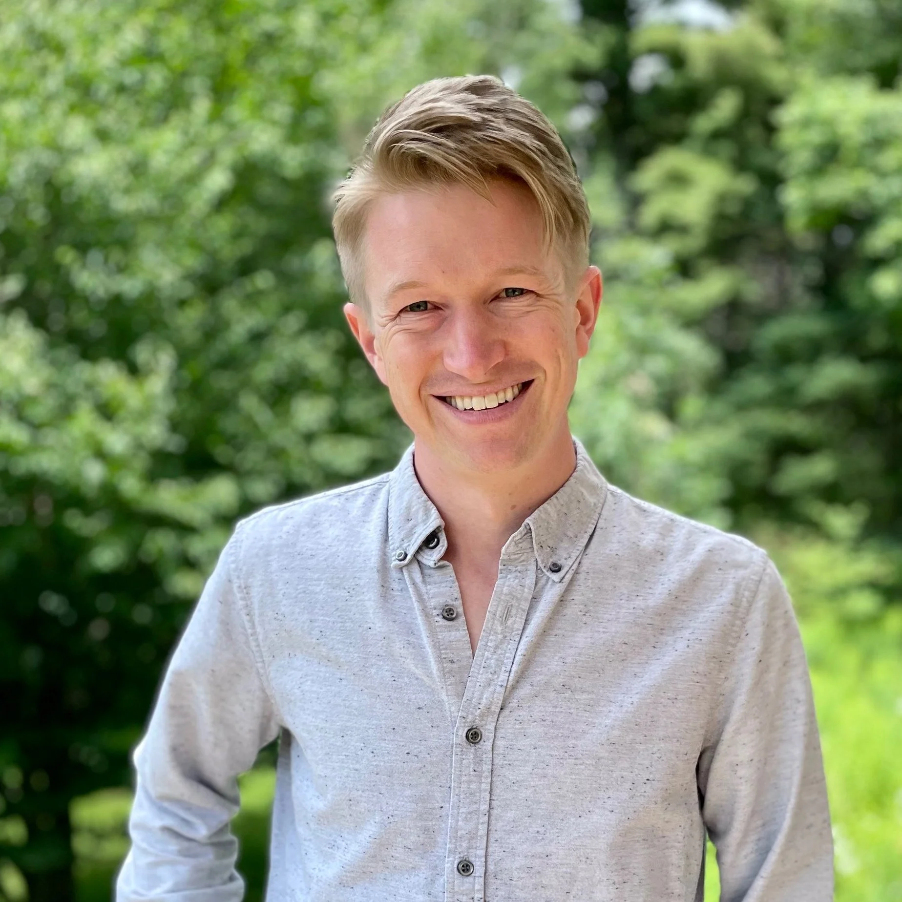 Andrew Herwig smiling confidently in an outdoor setting