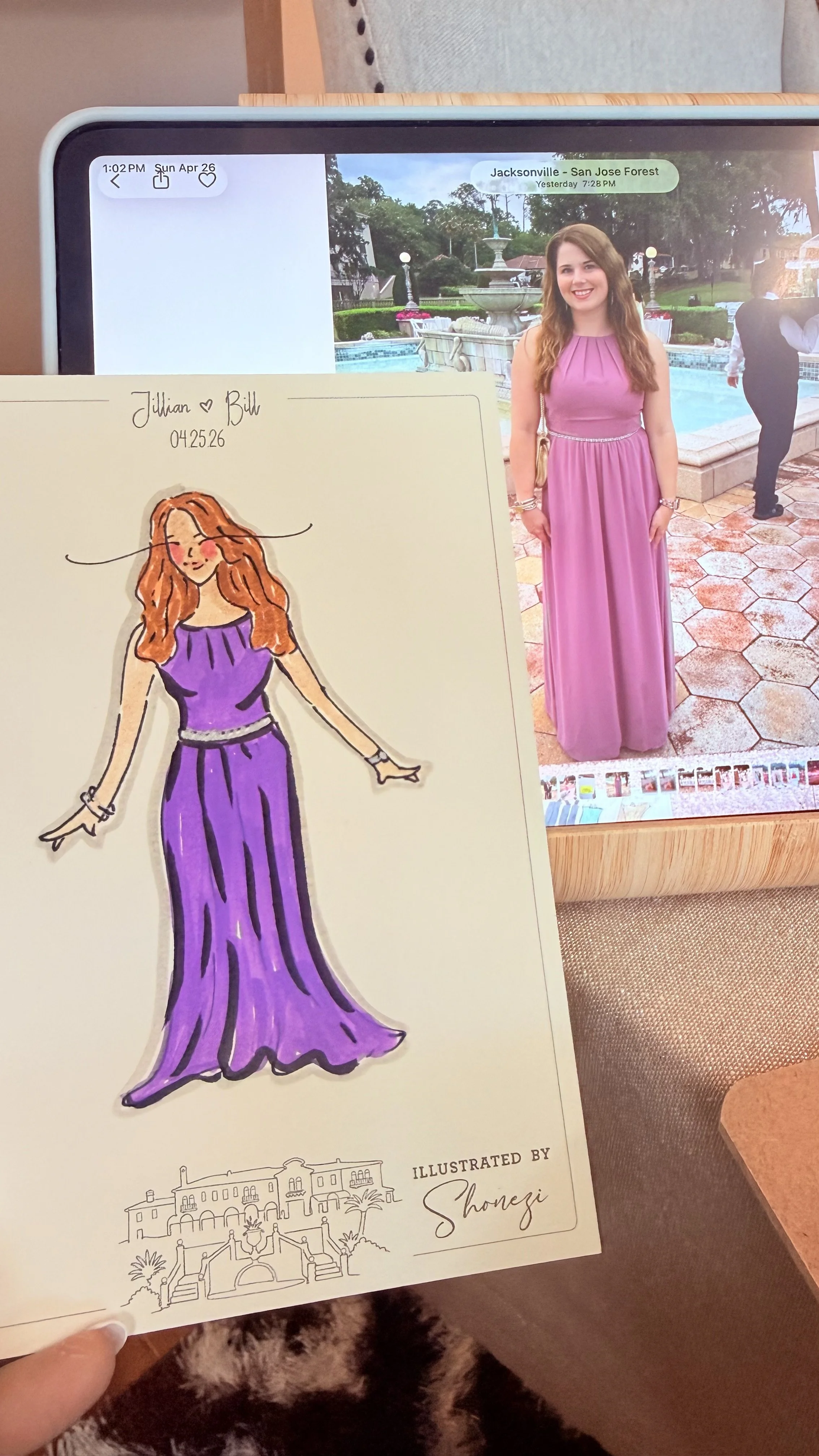 A woman in a pink dress standing outdoors near a fountain, with a hand-drawn fashion illustration of her in a purple dress held in the foreground.