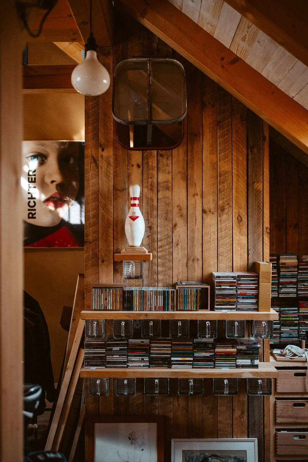 Holzwände mit einer Bowlingkugel, Kassetten, einem Poster und einer Glühbirne im Raum.