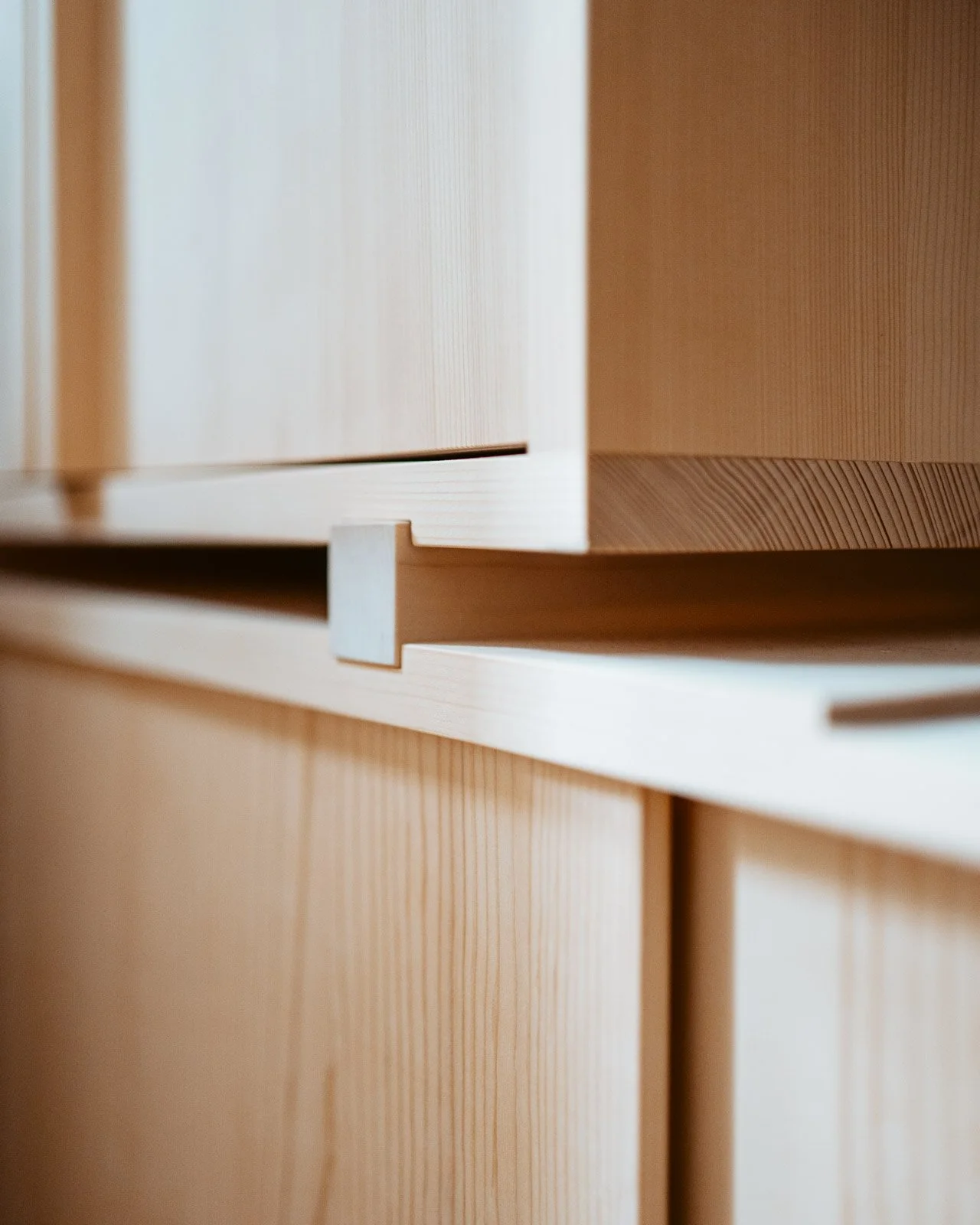 Nahaufnahme von Holzschränken mit sichtbarer Maserung und modernen Griffen.