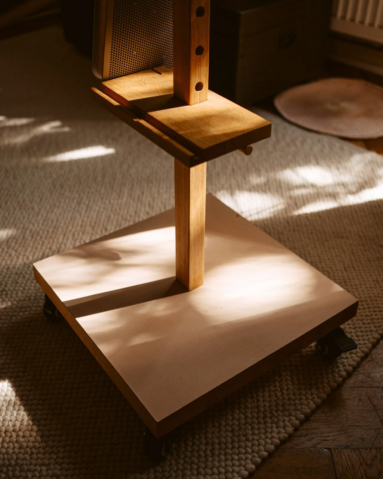 Ein mehrstöckiges Holzregal mit Rollen zum Bewegen, im Sonnenlicht.