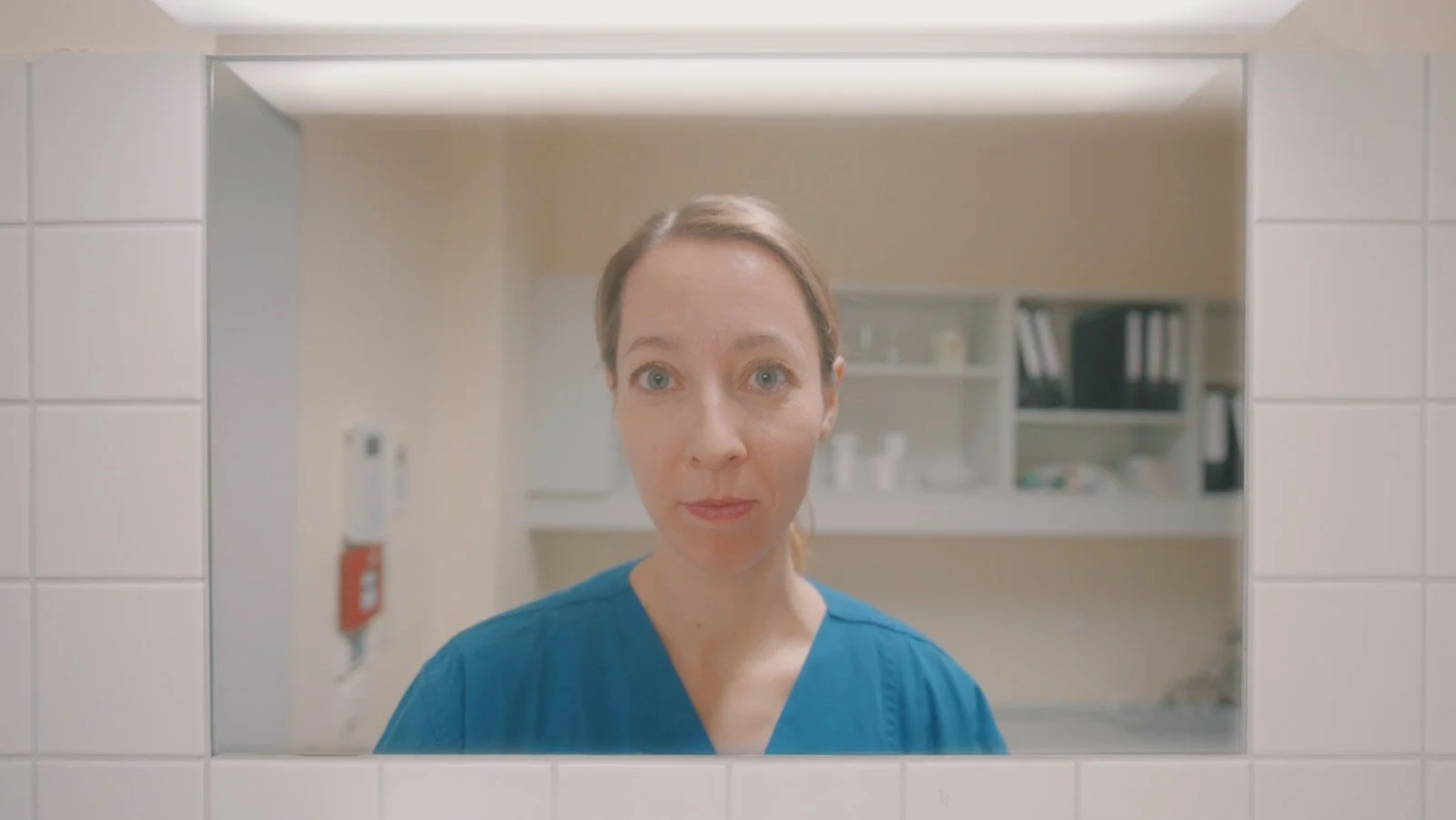 Ärztin blickt durch eine Fenster im Krankenhaus.