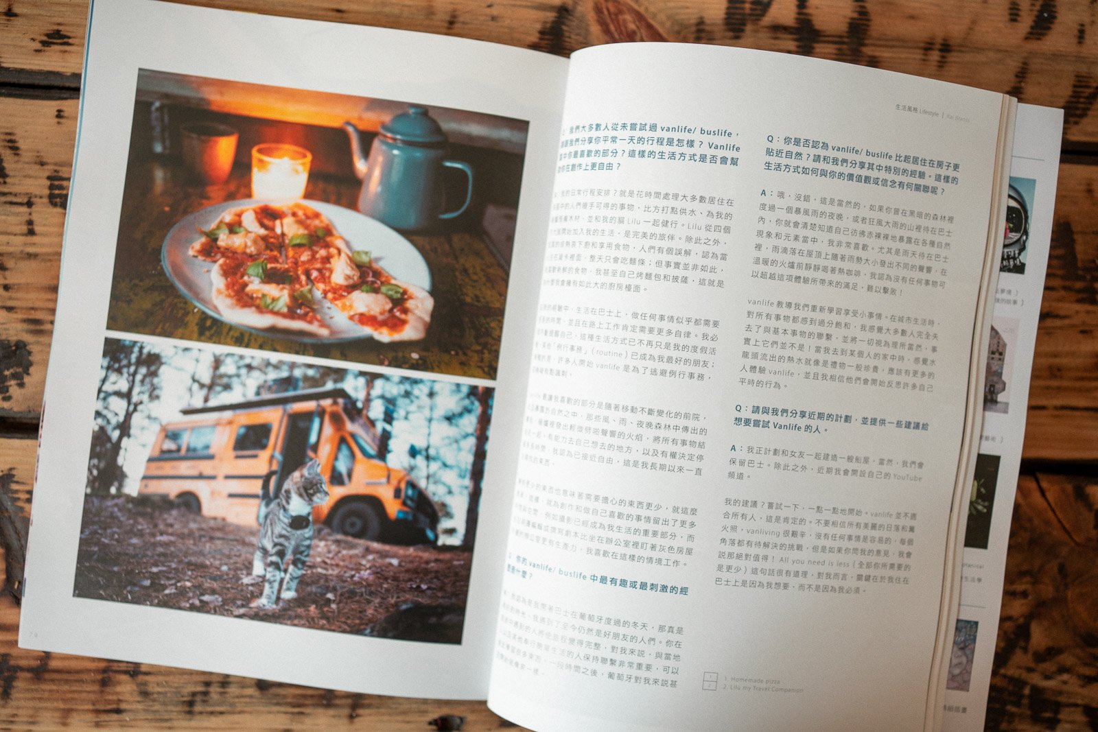 Ein aufgeschlagenes Buch mit zwei Fotografien auf der linken Seite, oben eine Pizza mit Basilikum, Kerze und Teekanne, unten ein Van mit einem Tierschneele auf einem Feld.