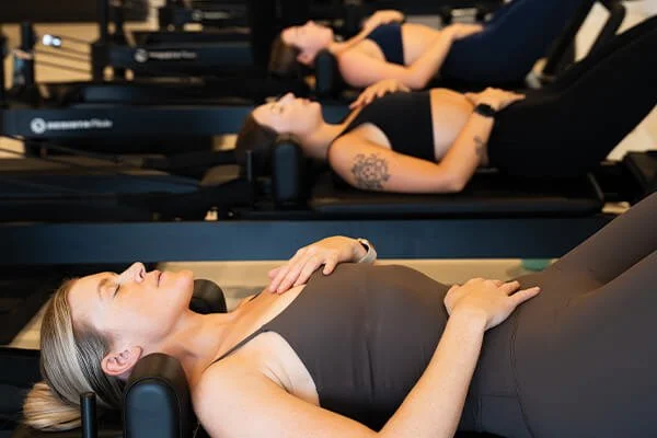 Group of women stretching and relaxing inside a reformer Pilates studio in Buderim