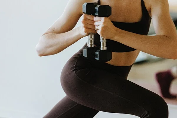 Woman holding weights and twisting her body during a Mat Pilates class in Bli Bli