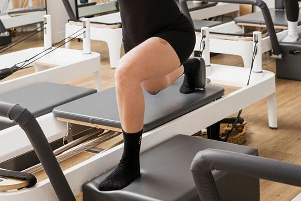 Woman lunging forward during a class inside a reformer Pilates studio in Bli Bli