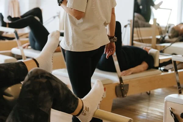 Group of women participating in a beginner pilates class in Beerwah with pilates instructor walking around the room