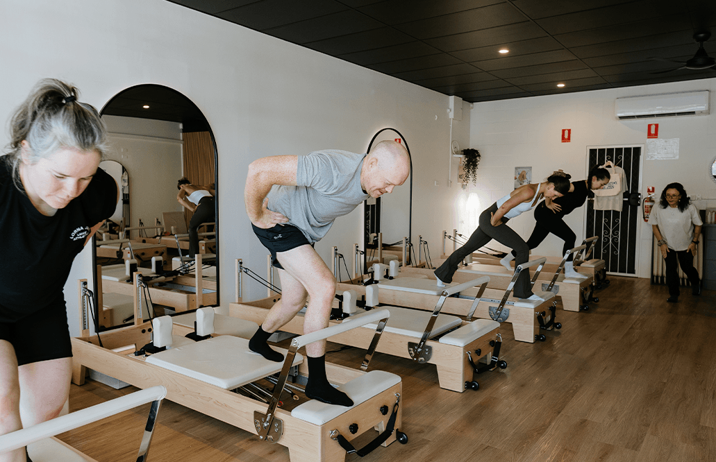 Man and several women participating in a reformer pilates class in Beerwah