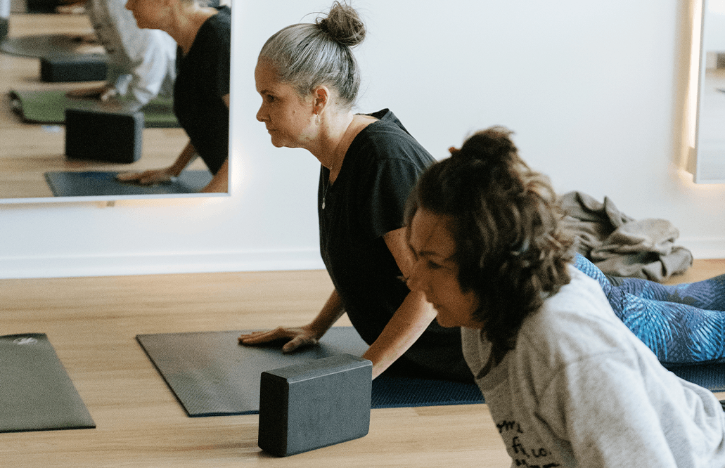 Older women pushing themselves up from the floor during a yoga class in Beerwah