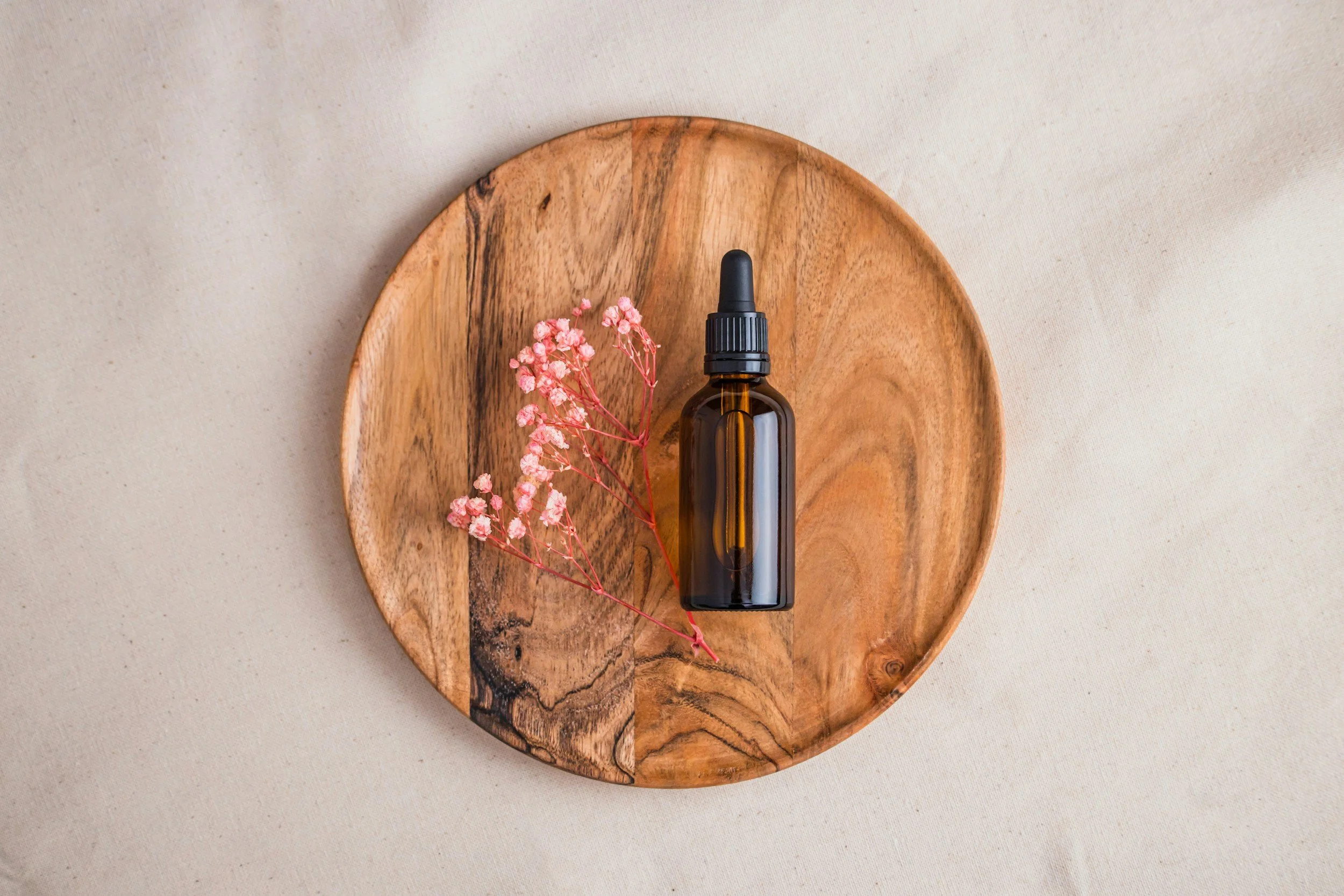 Amber tincture bottle surrounded by fresh Lemon Balm leaves in soft natural light.