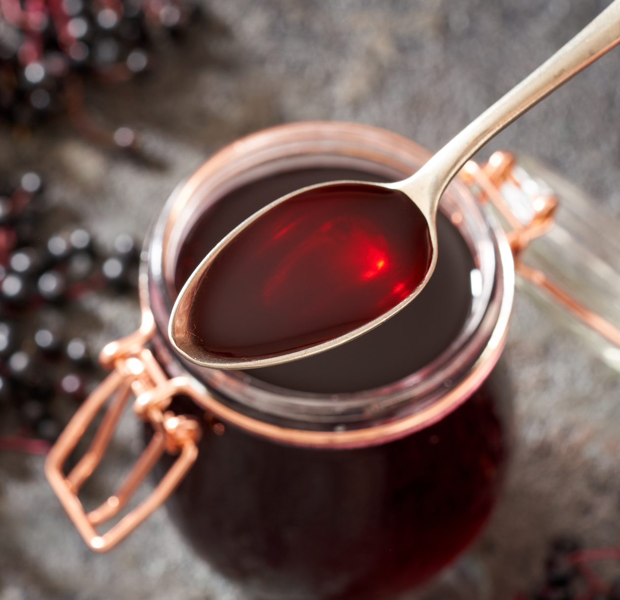 Elderberry syrup in jar with spoon.