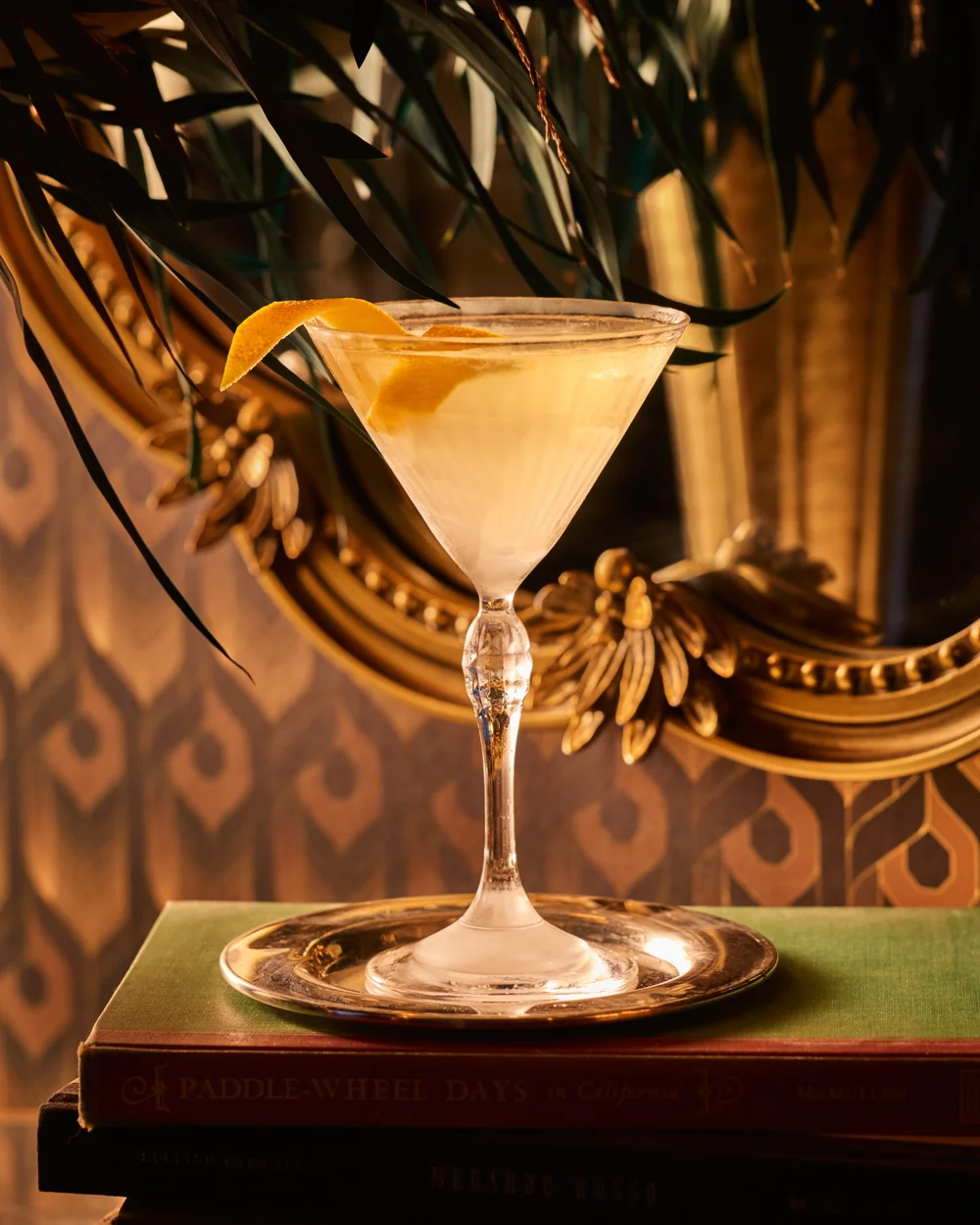 A cocktail in a vintage coupe displayed in front of a mirror