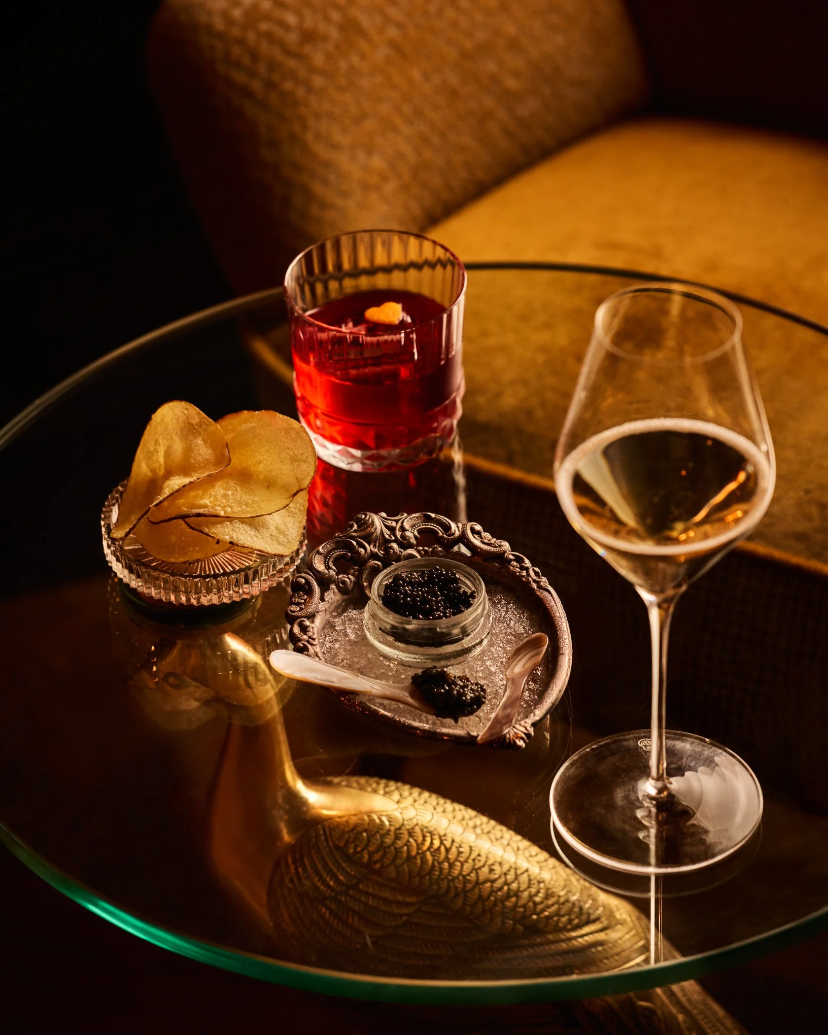 Chips, champagne, caviar, and cocktail on glass plate. Photo credit: Nicola Parisi
