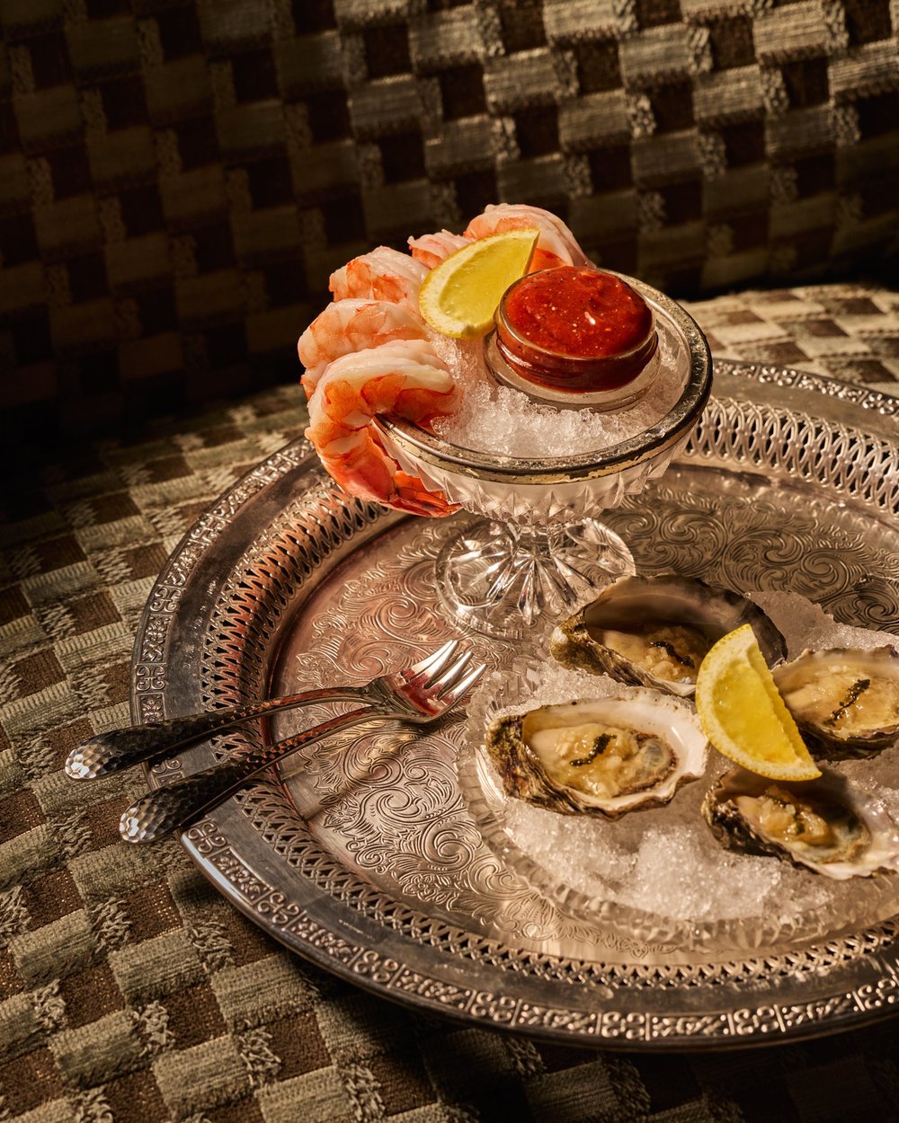 Shrimp cocktail and oysters presented together on a tray