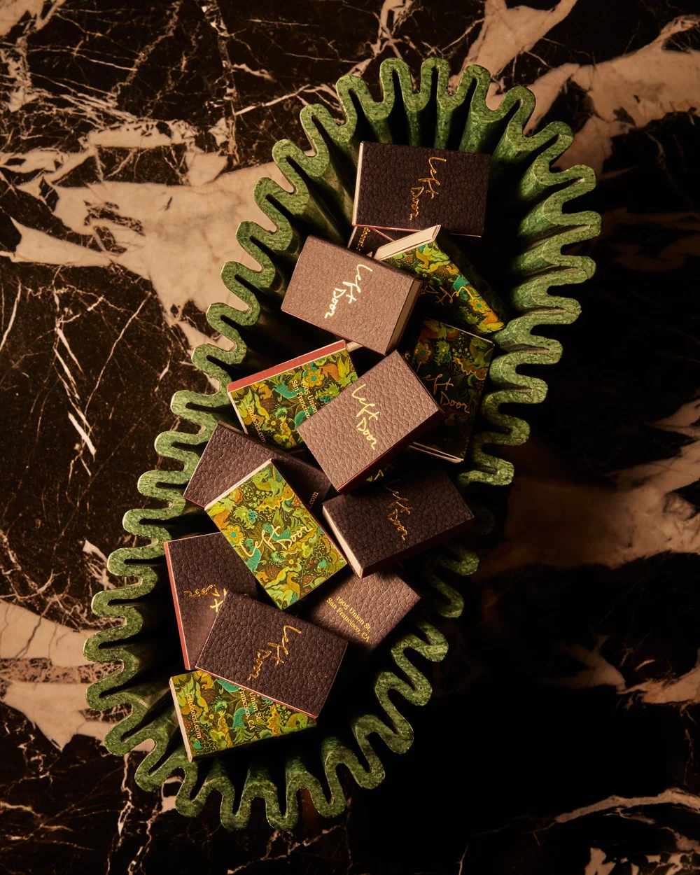 Left Door matchbooks gathered in an ornate jade-green bowl