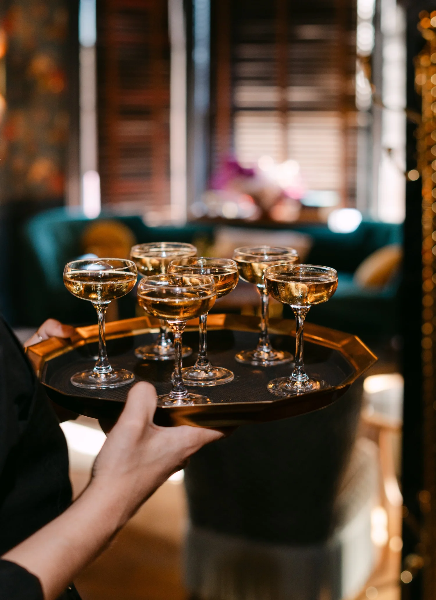 A server carrying a tray of Champagne coupes at Left Door