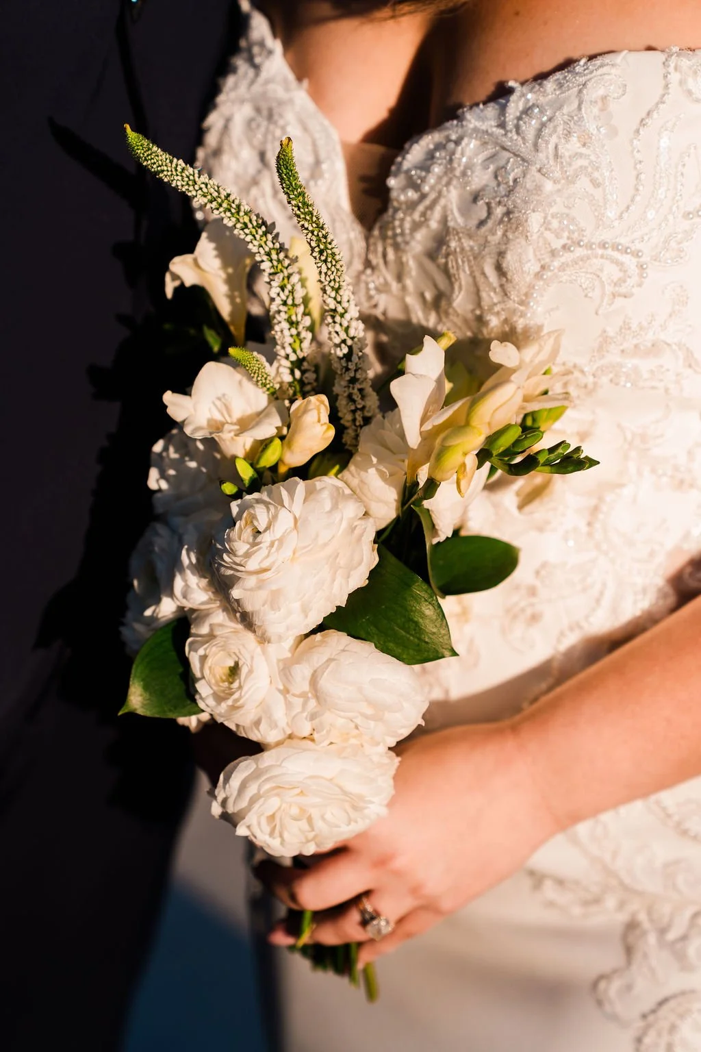 Close up of woman's hands holding white floral bouquet
