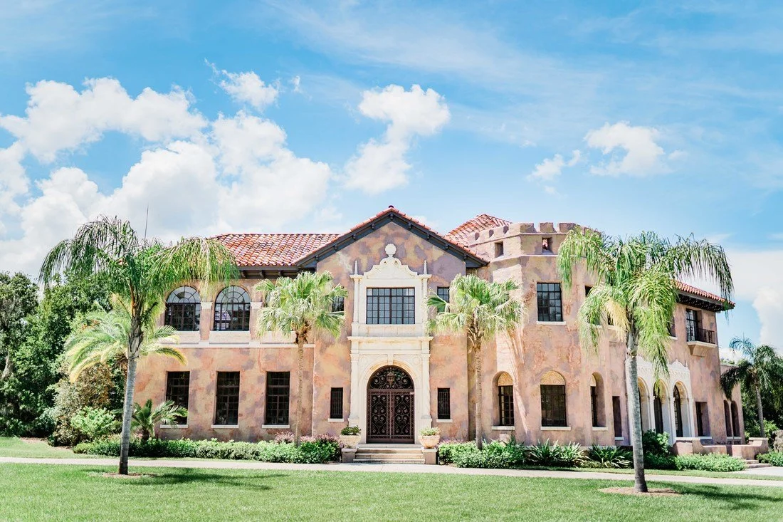 Brown plaster walled historic mansion with palm trees