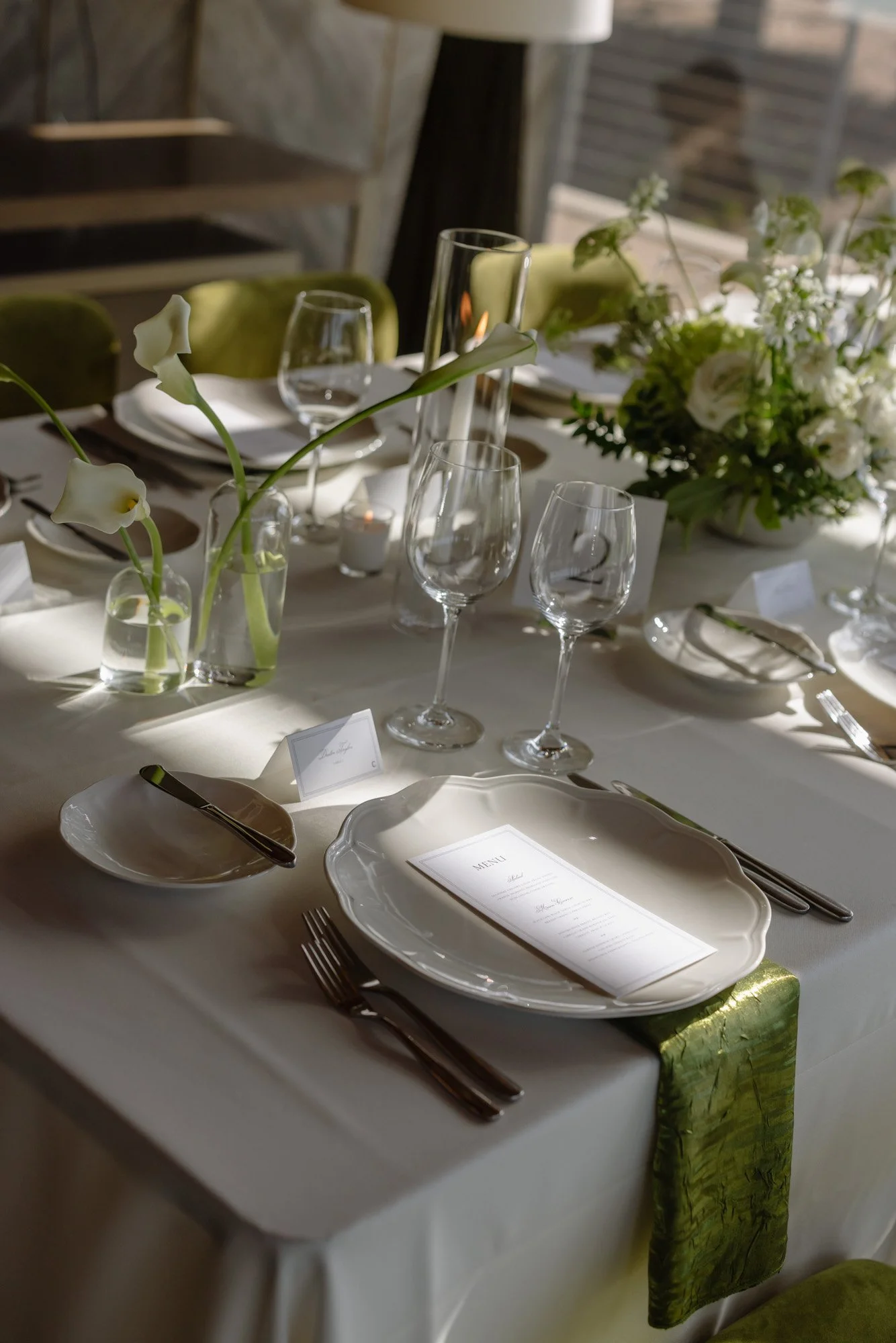 Elegant green and white wedding tablescape with candlelight and printed menus at a California wedding reception