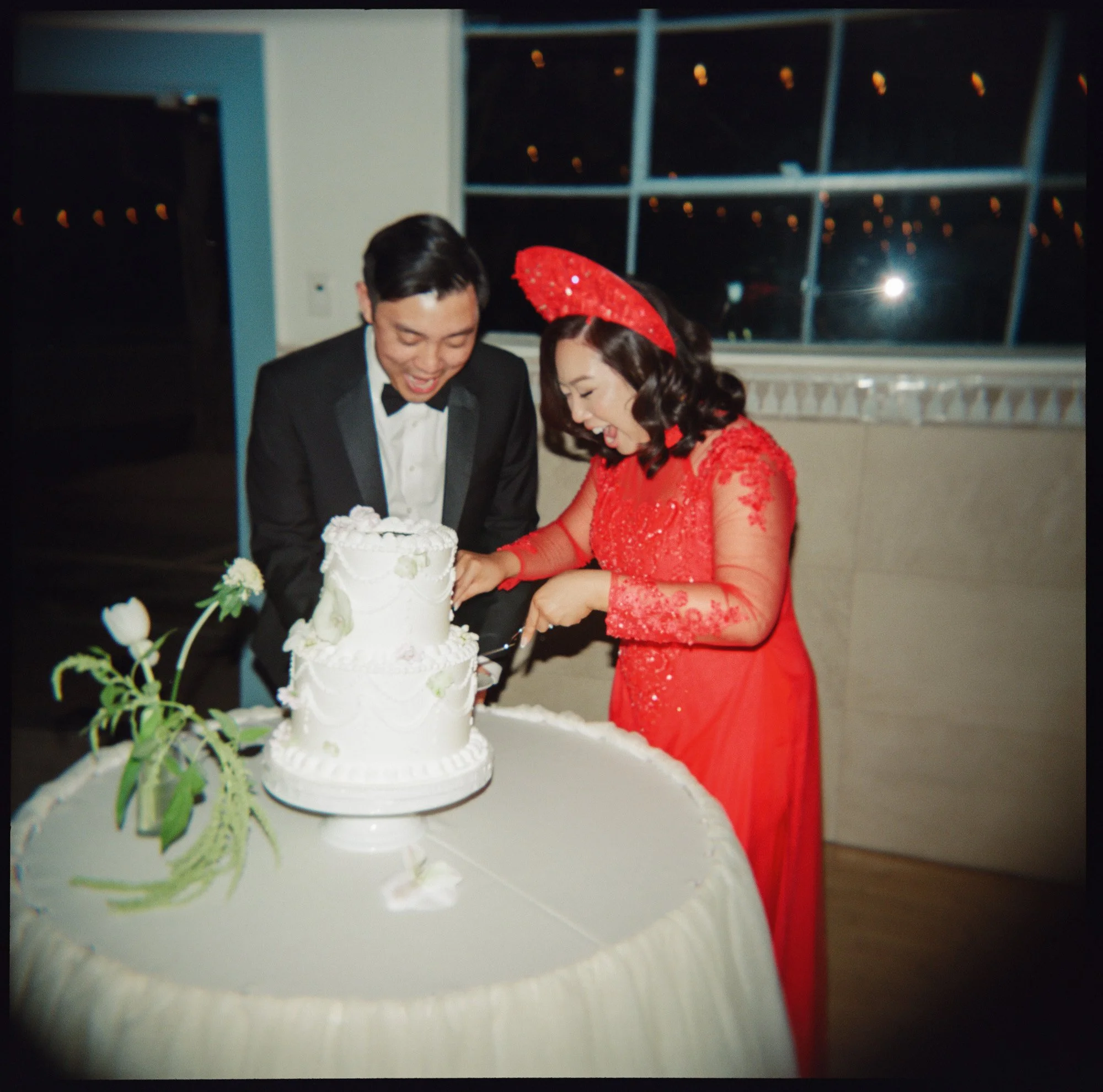Couple cutting their wedding cake during a documentary-style California wedding reception, captured on film photography
